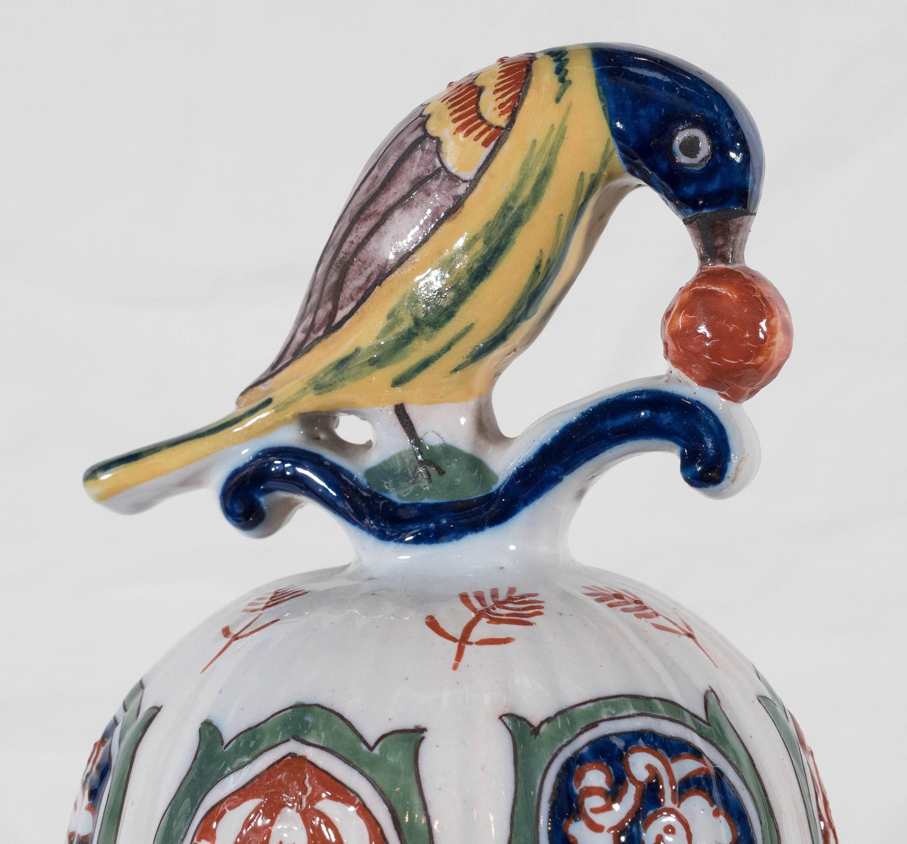 A pair of colorful Dutch delft polychrome vases painted in the traditional Kashmir palette of cobalt blue, green and orange with touches of bright yellow. The vases are ribbed and decorated with scenes of long-tailed birds in a flower-filled garden.