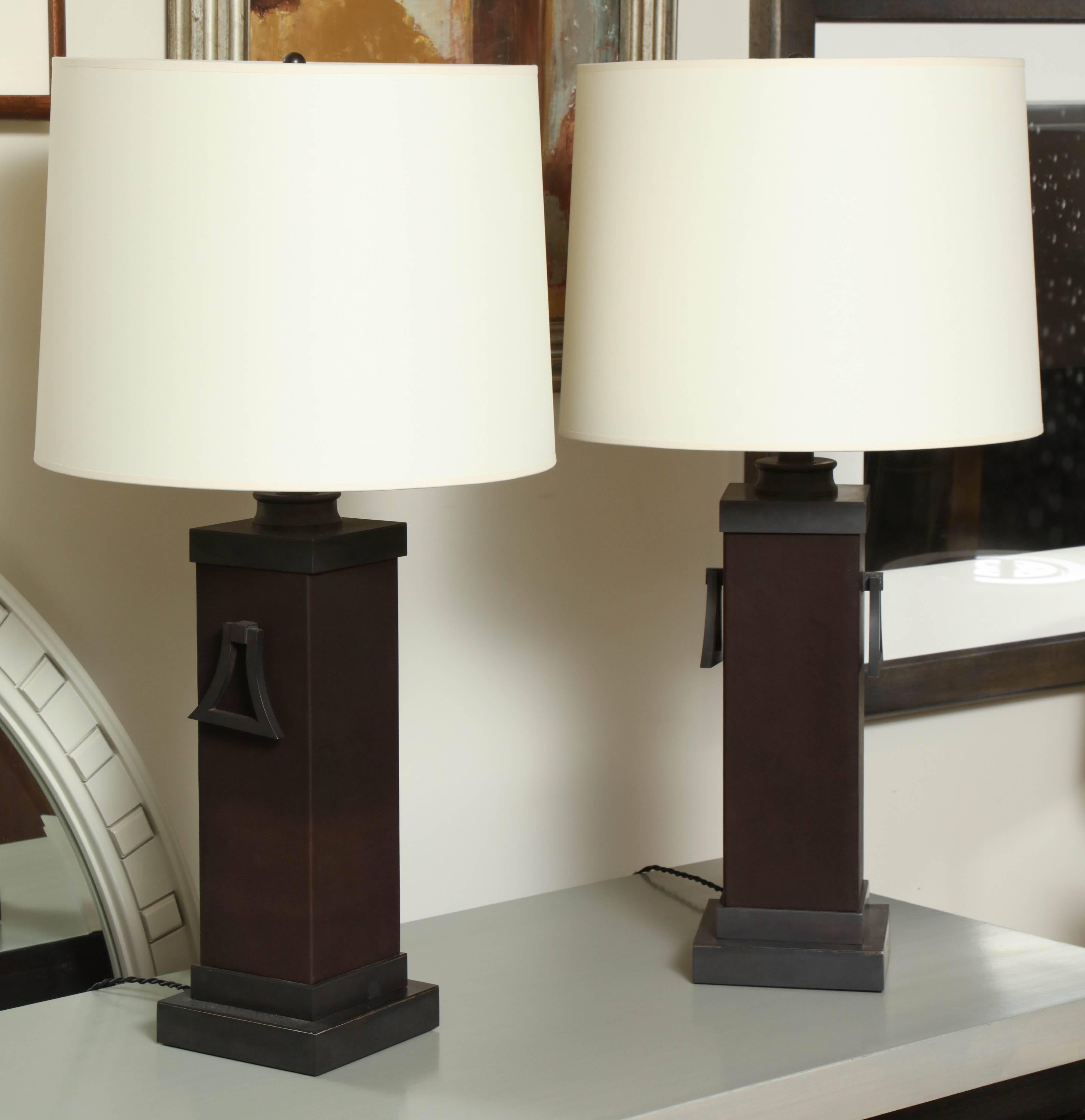 Pair of James Mont square column table lamps; metal components have been finished in bronze, new two-bulb sockets, and the columns have been clad in leather; new silk shades with rolled edges.