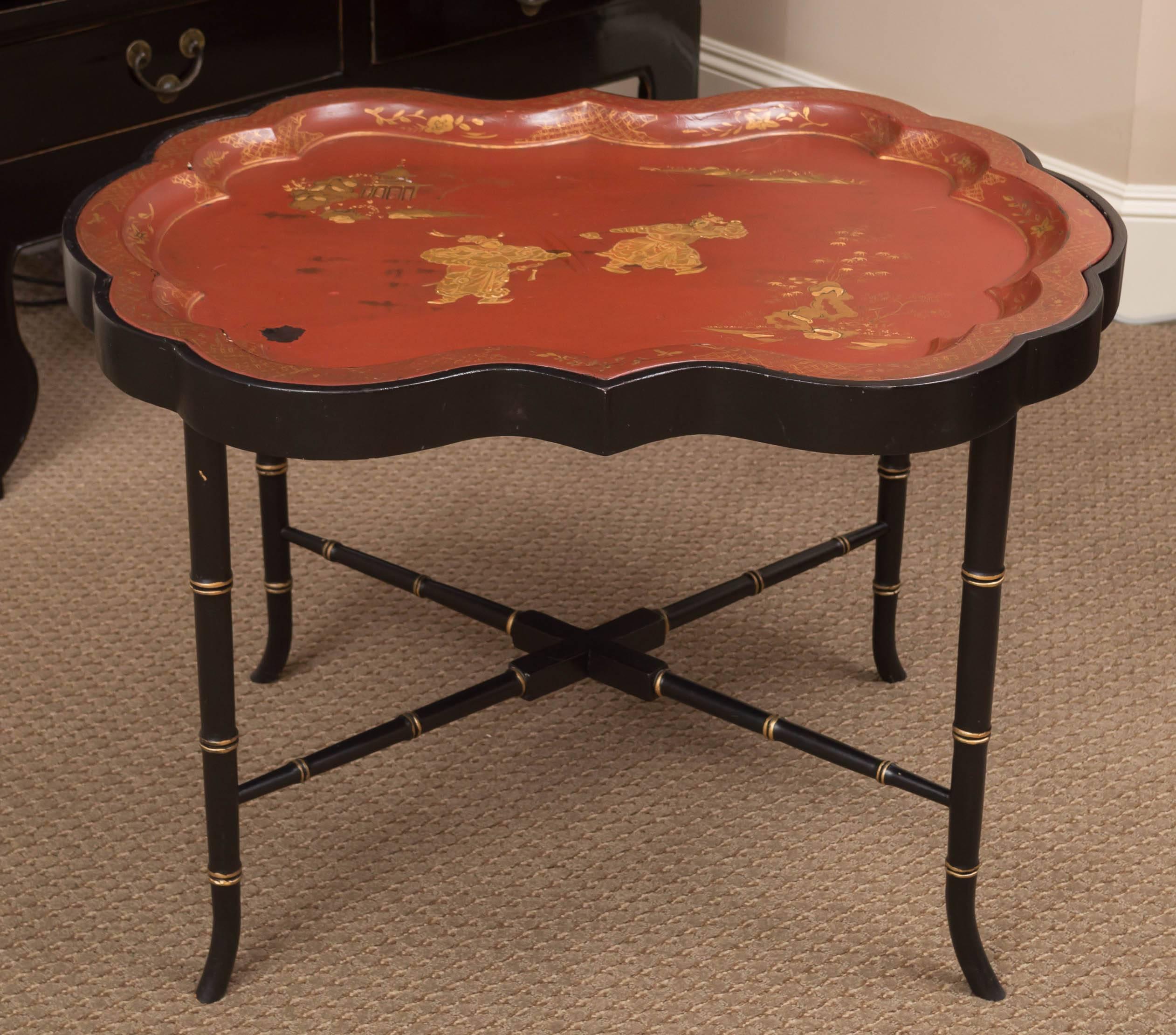 The shaped tray depicting two military figures in a garden on a fitted ebonized stand raised on tapered legs joined by cross-stretchers.