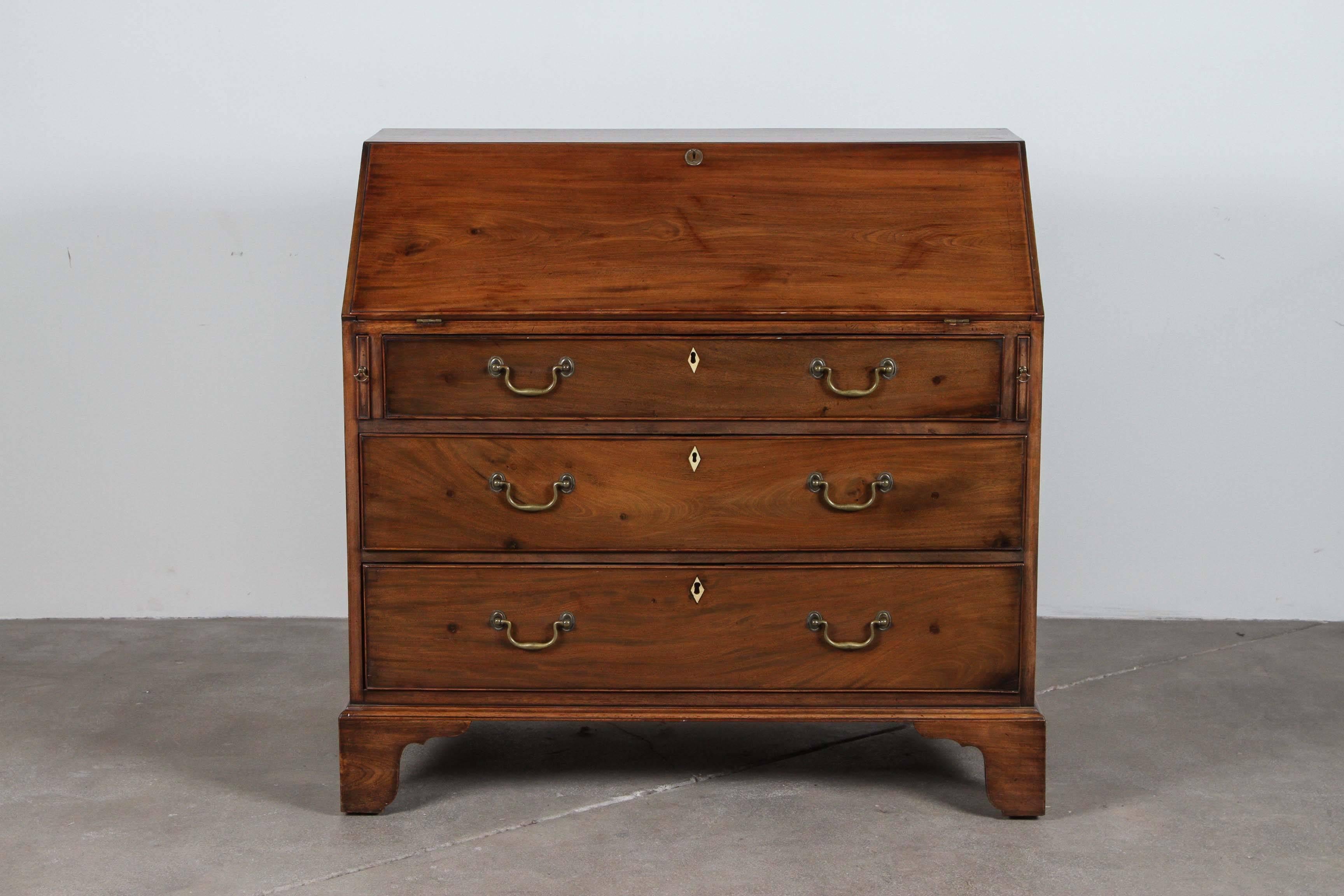 Traditional drop-leaf mahogany secretary desk with three large drawers. Brass pulls and interior moulding details.