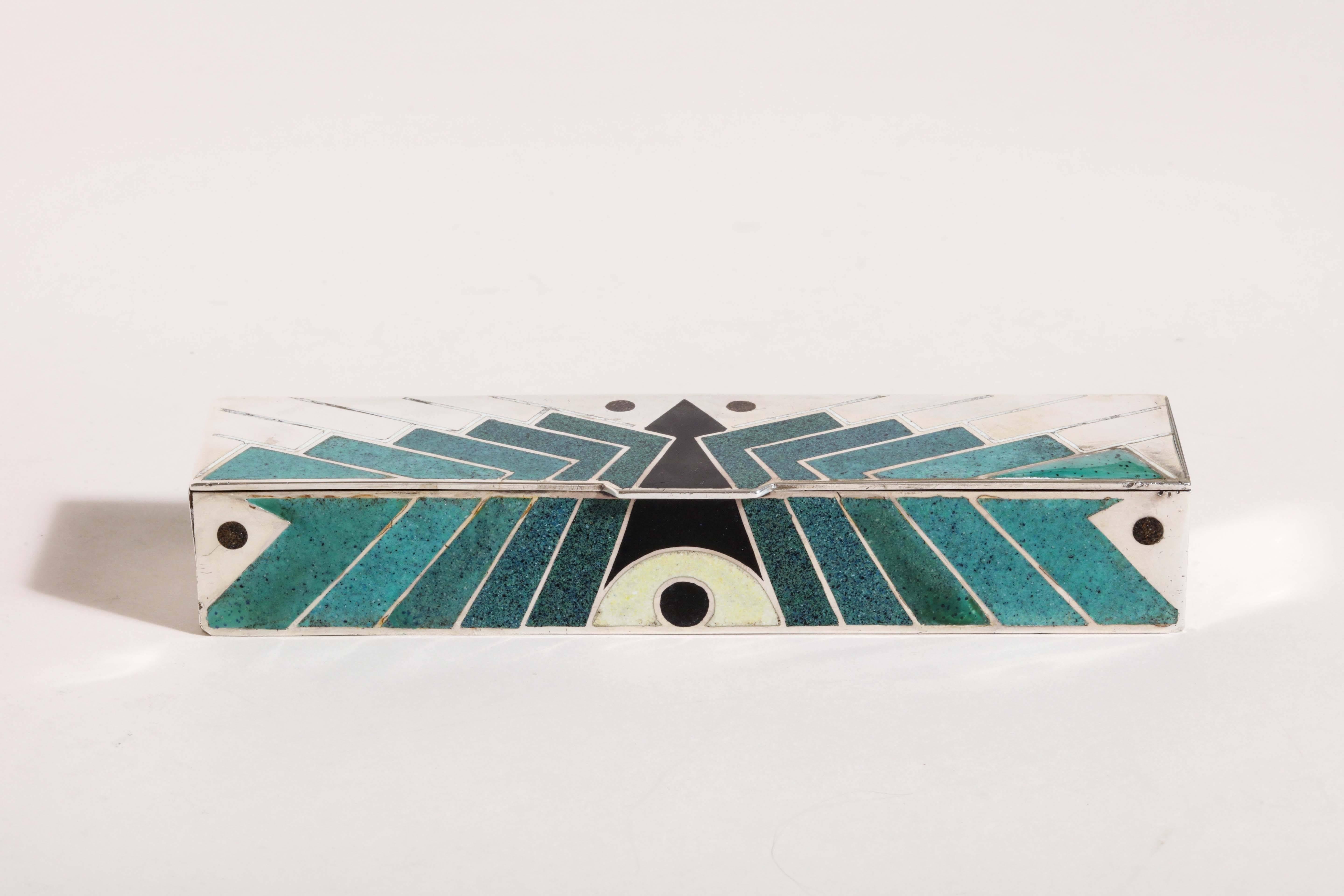 Measures: 6 ¾” wide; 1 ¾” long’ 1” high.
12.25 ozs. gross.

With green, blue and black geometric design in champlevé enamel.
Inscribed Jean Goulden/ LX 28/ Goulden silver poincon.

Provenance: Galerie du Luxembourg, Paris.
Exhibited: Galerie