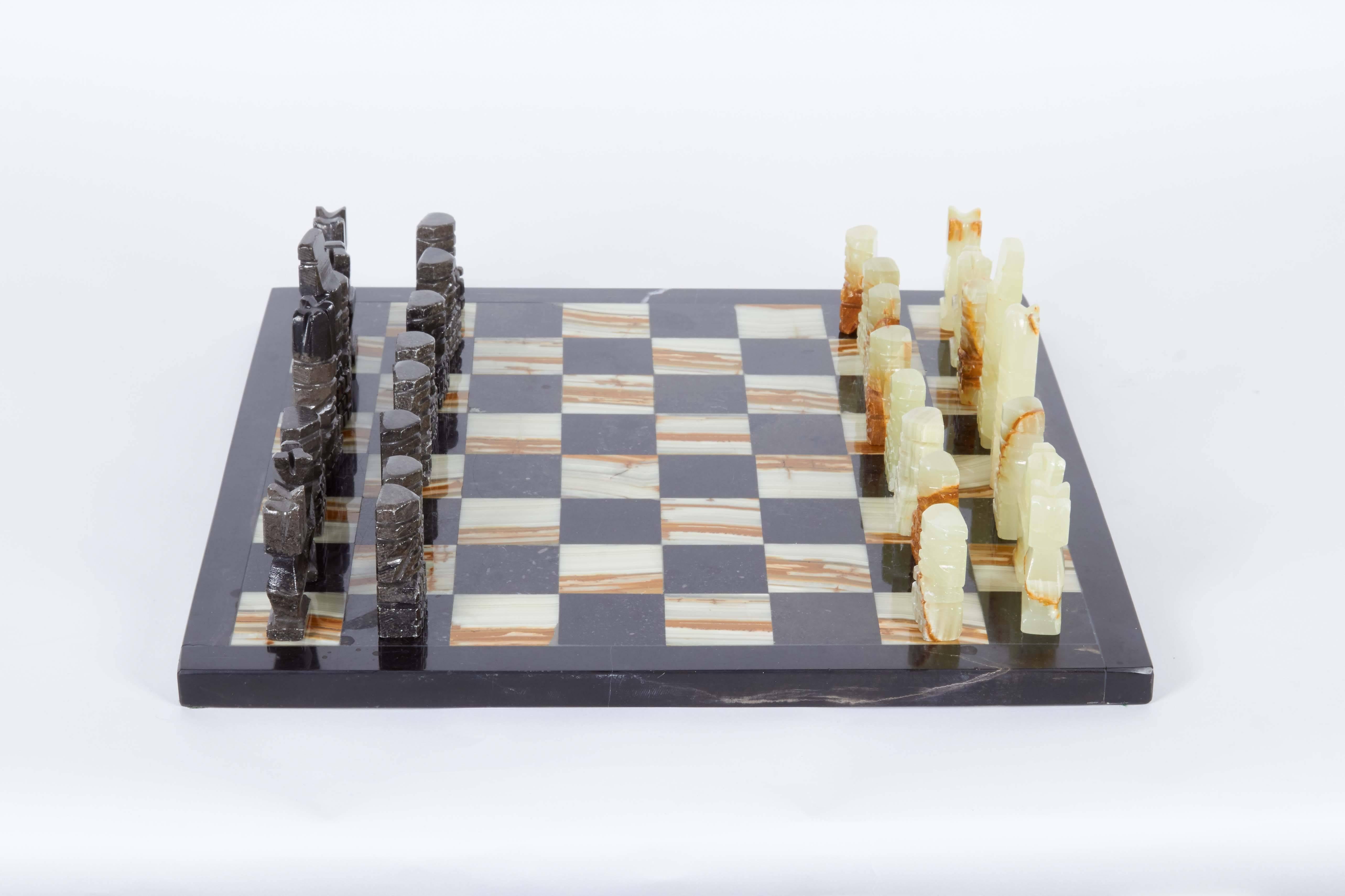 A chess board and 32 carved abstract pieces in onyx and black marble, produced in Mexico circa 1960s-1970s. Very good vintage condition, wear consistent with age and use.

Dimensions:
Board - .63