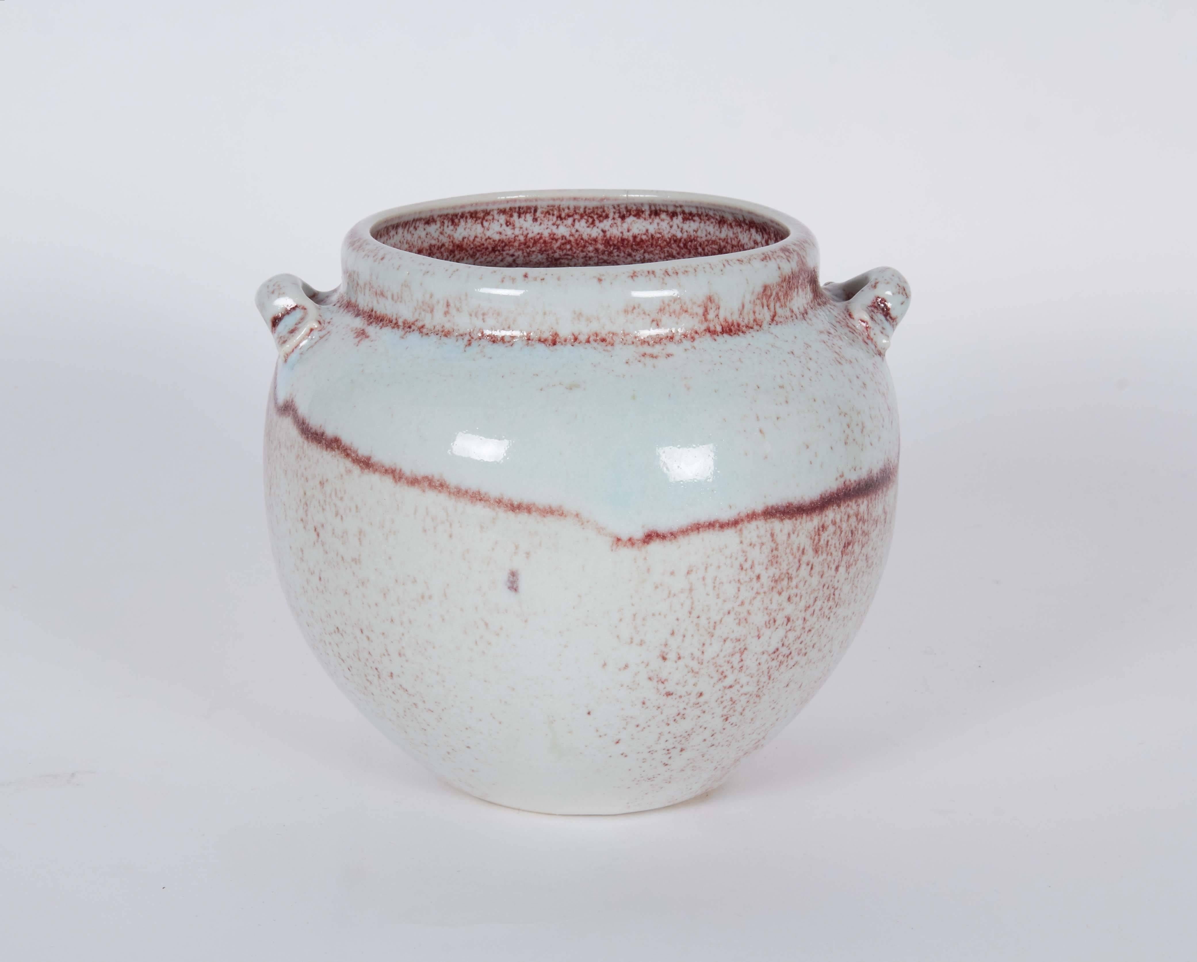 A ceramic handled urn by contemporary ceramic artist Ron Dier, the round body with white and pink glazes. Markings include [H] [Dier] signed to the base.

10480