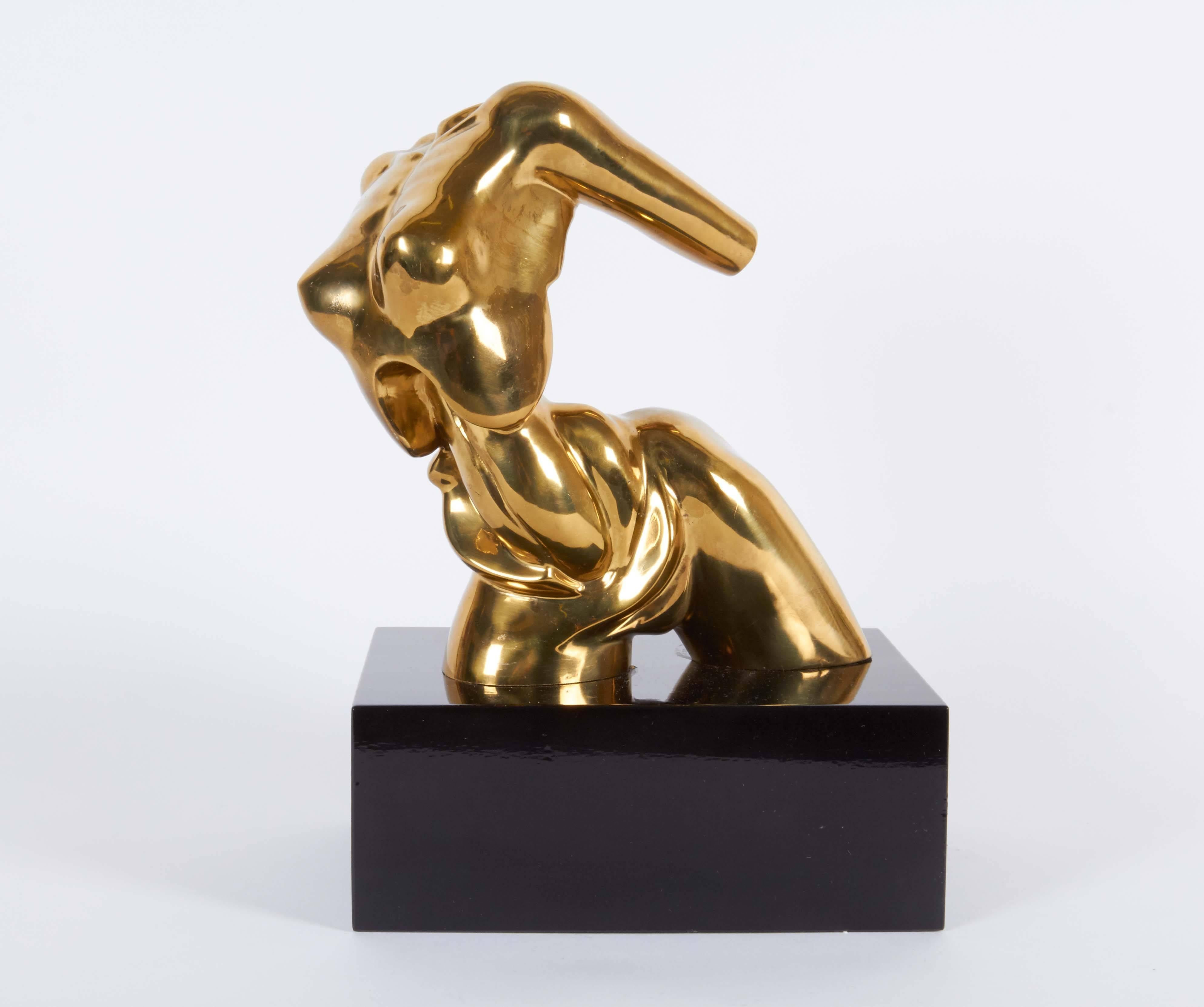 A modernist bronze sculpture by Hattakitkosol Somchai (Bangkok, 1934-2000), depicting a female torso in mid-motion, evoking the Futurist style, mounted on a black lacquered wood base. Markings include [Somchai] and edition number [18/1000] to the