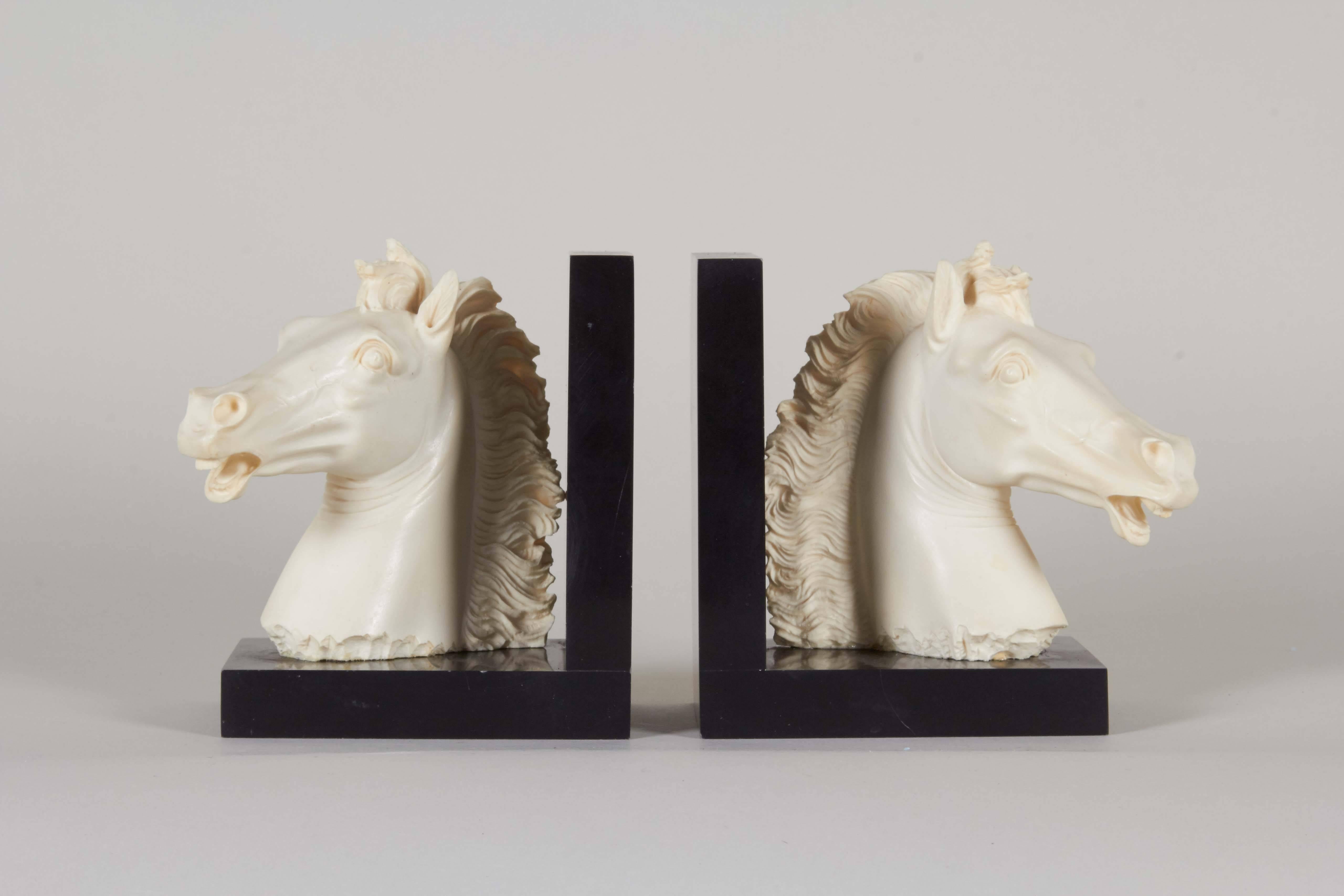 Italian circa 1970s bookends, depicting horse heads crafted of alabaster composite, designed by Arnaldo Giannelli, on black bases. Markings include signature [A Giannelli] and label (albeit worn) [Golden Crown E&R Italy]. Very good condition, wear