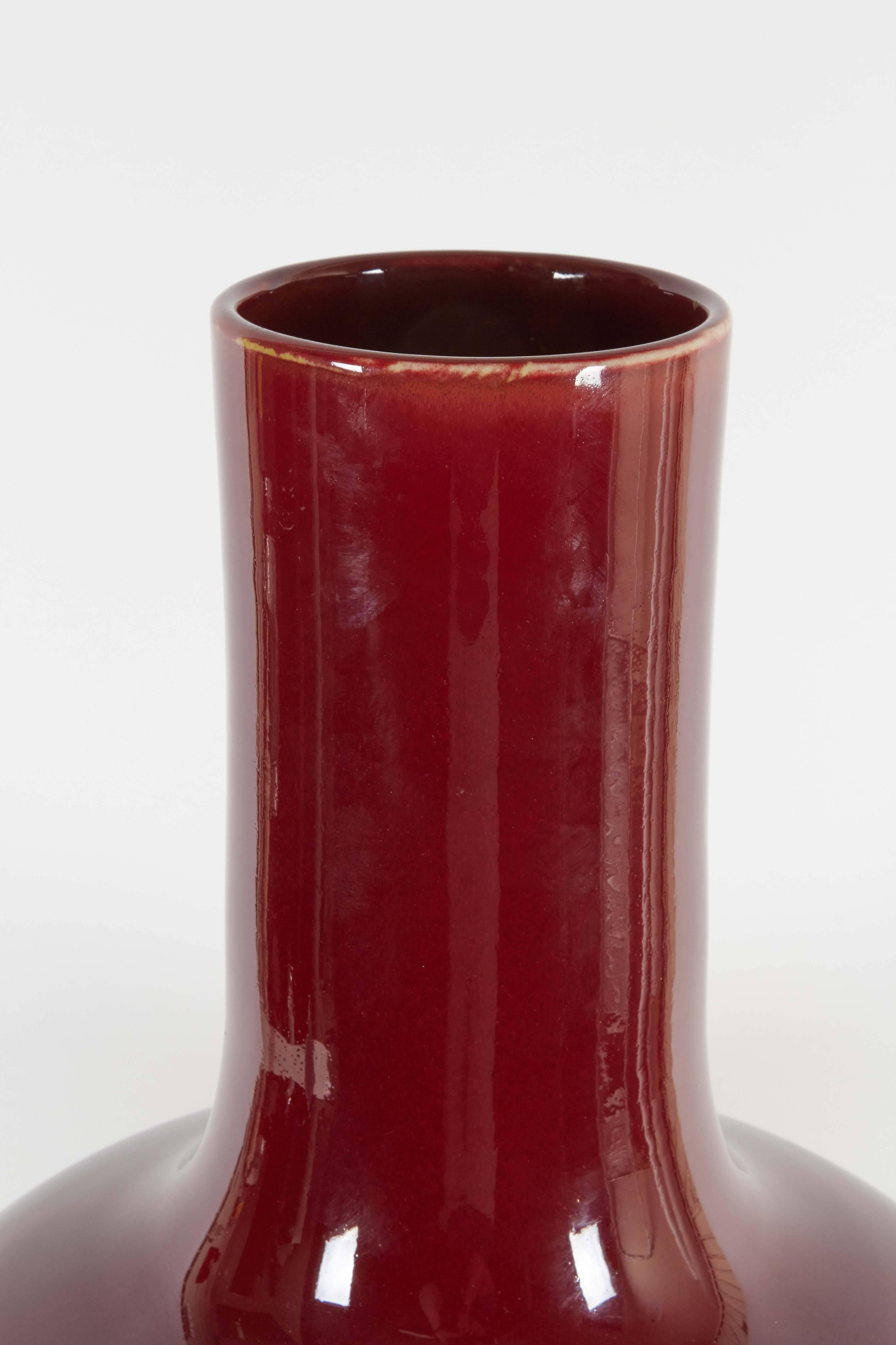 A Chinese ceramic vase, produced circa 1930s-1940s, flame glazed in deep red. Includes marks to base. This piece remains in very fine condition, wear to base consistent with age.

10434