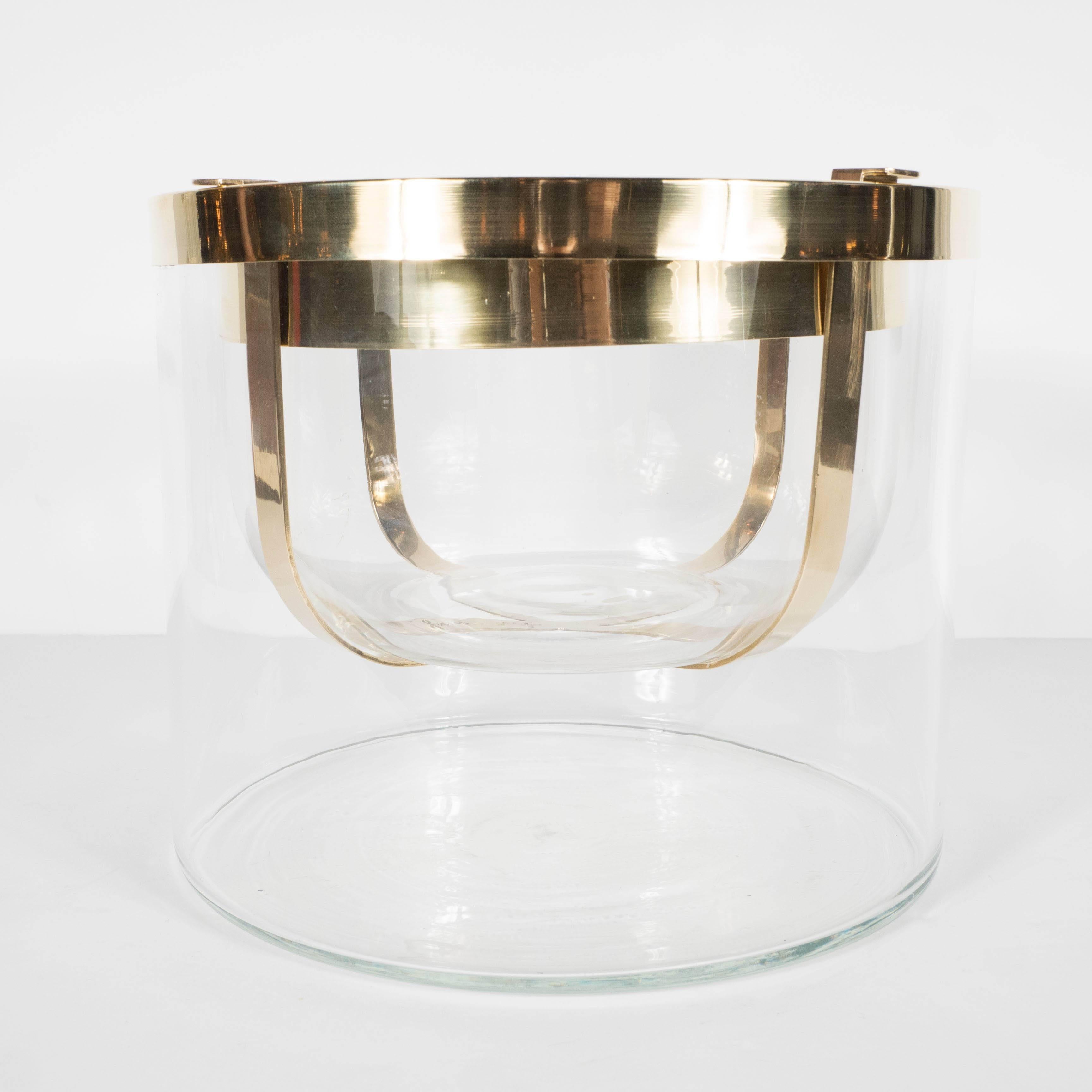 A rare and exquisite caviar server in clear glass and polished brass by Gabriella Crespi. A circular, handblown glass base with a polished brass trim supports a four-hooked brass frame which holds a central glass dome, also detailed in brass. The