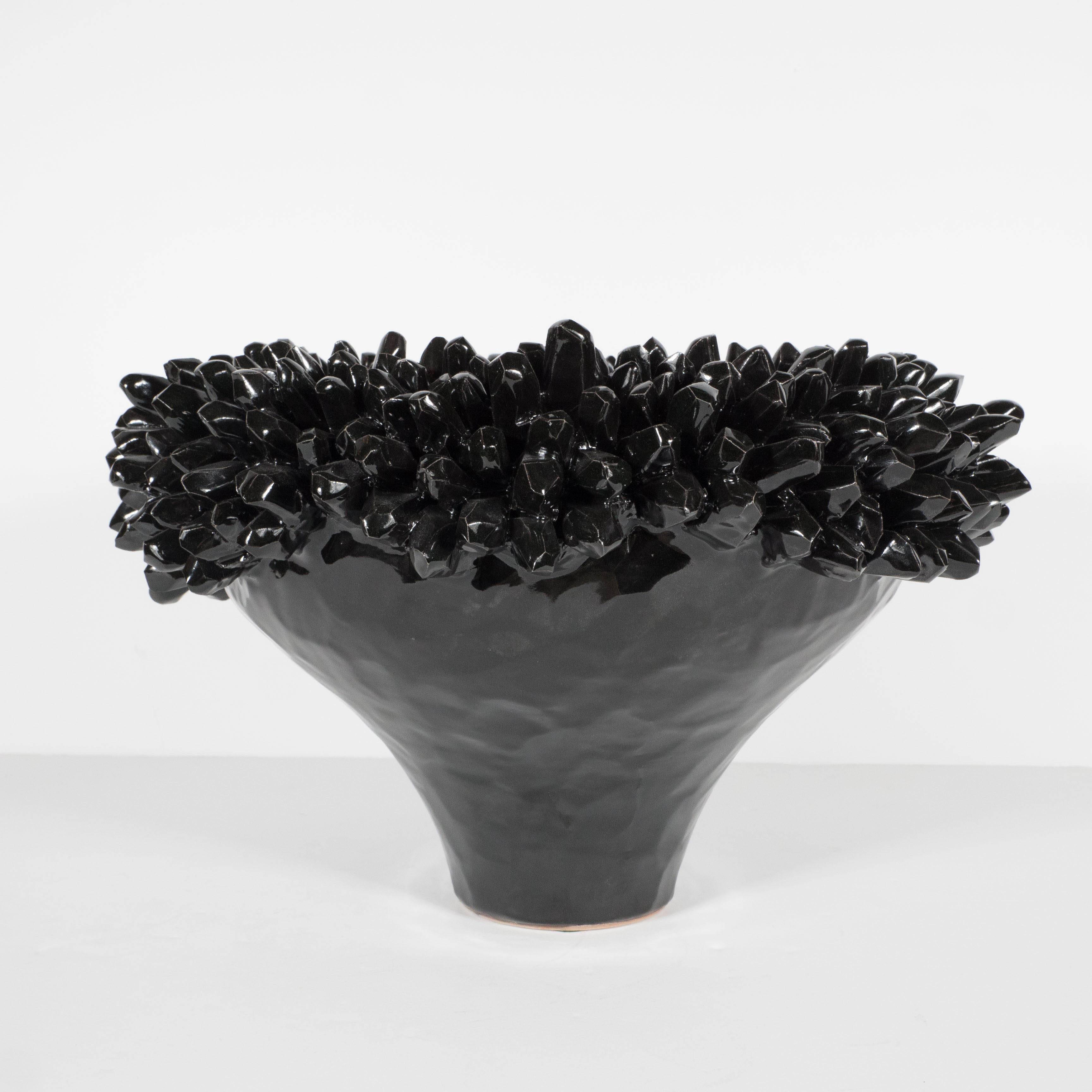 A Mid-Century ceramic bowl in a glazed jet black. The spiky details along the perimeter resemble that of a sea urchin. This piece is in excellent condition. A wonderful accent or centerpiece bowl.