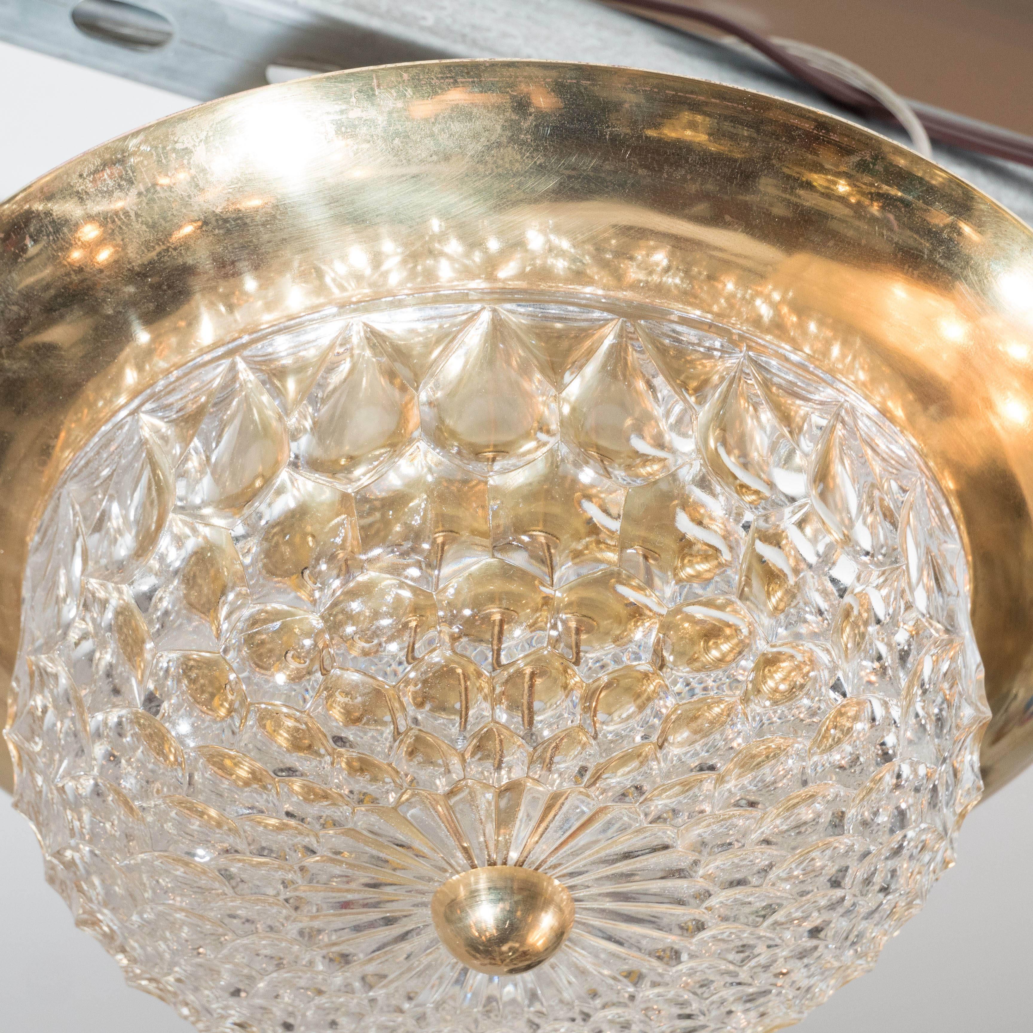 A Mid-Century Modernist flush mount chandelier with polished brass fittings. A diamond shape faceted crystal dome is supported by a polished brass fitting and contouring frame. It has been completely rewired and is in excellent condition.