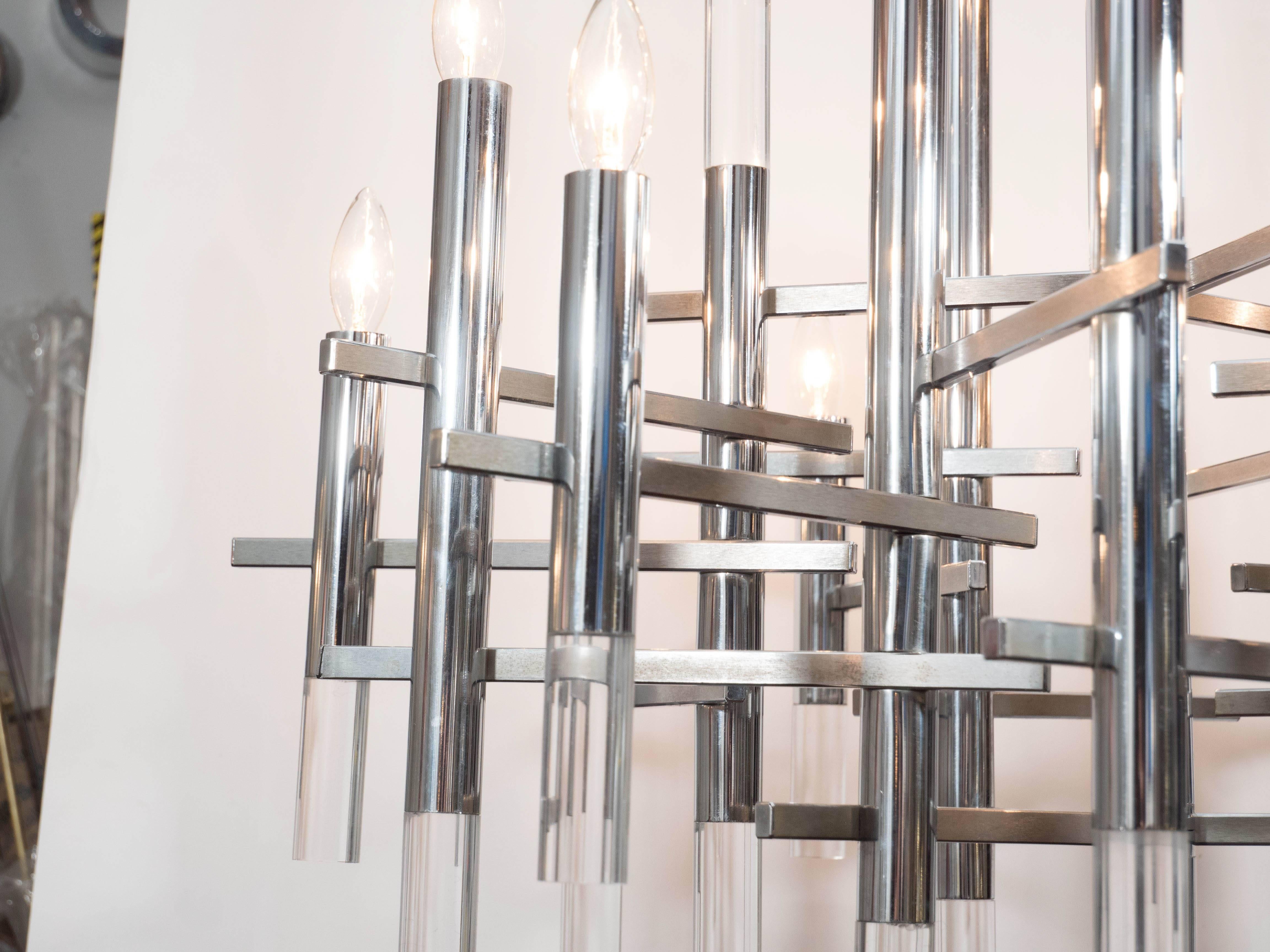 Ce lustre à segments en chrome et Lucite, de style moderne du milieu du siècle, a été réalisé en Italie par le célèbre atelier d'éclairage Gaetano Sciolari. Une abondance de cylindres en chrome poli, avec des fonds en lucite, s'attachent à une tige