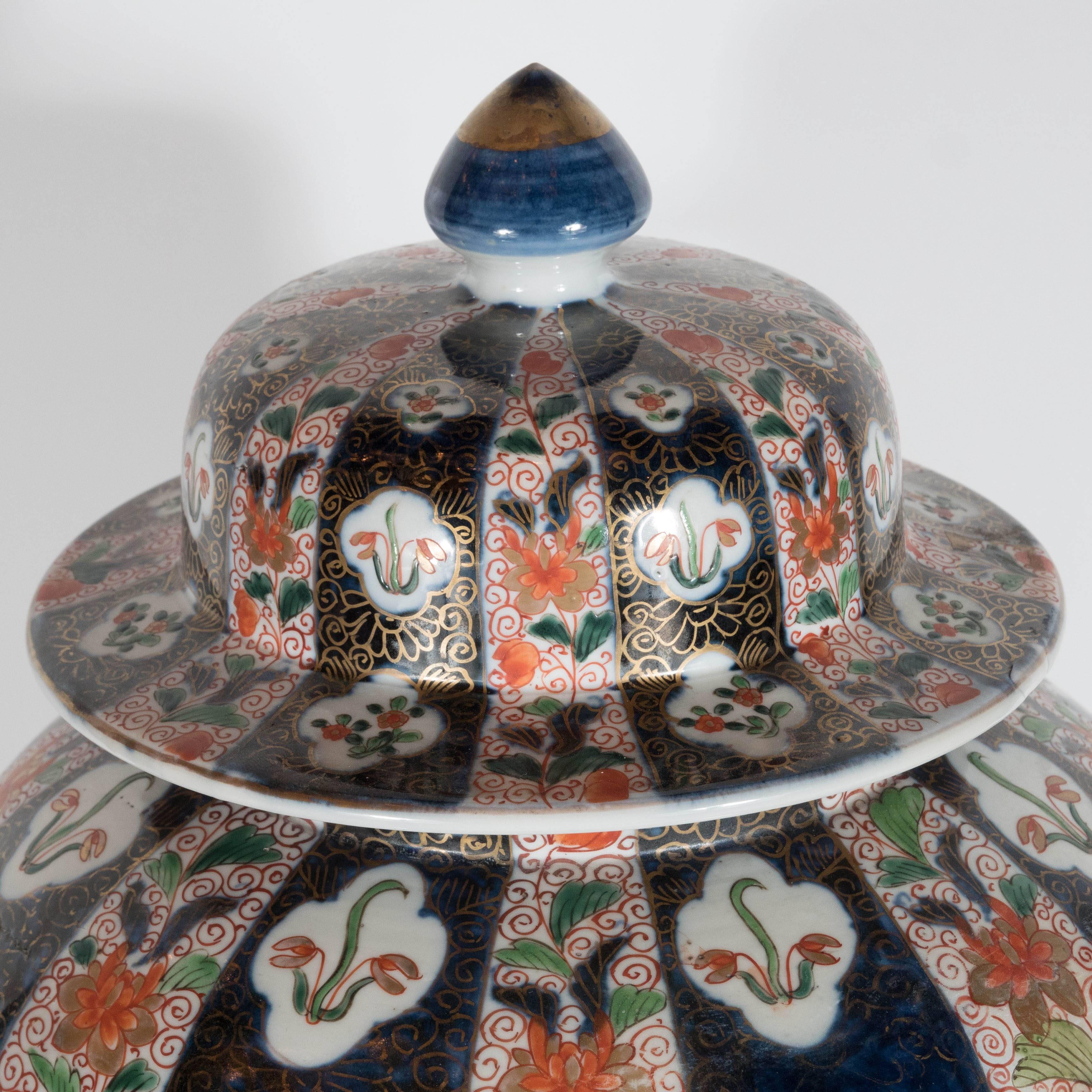 This gorgeous pair of large-scale lidded vases/ urns are decorated with a hand-painted beautiful floral /fauna and geometric decoration. The color palette is all rich jewel tones with a pearl background. These were purchased at William Doyle