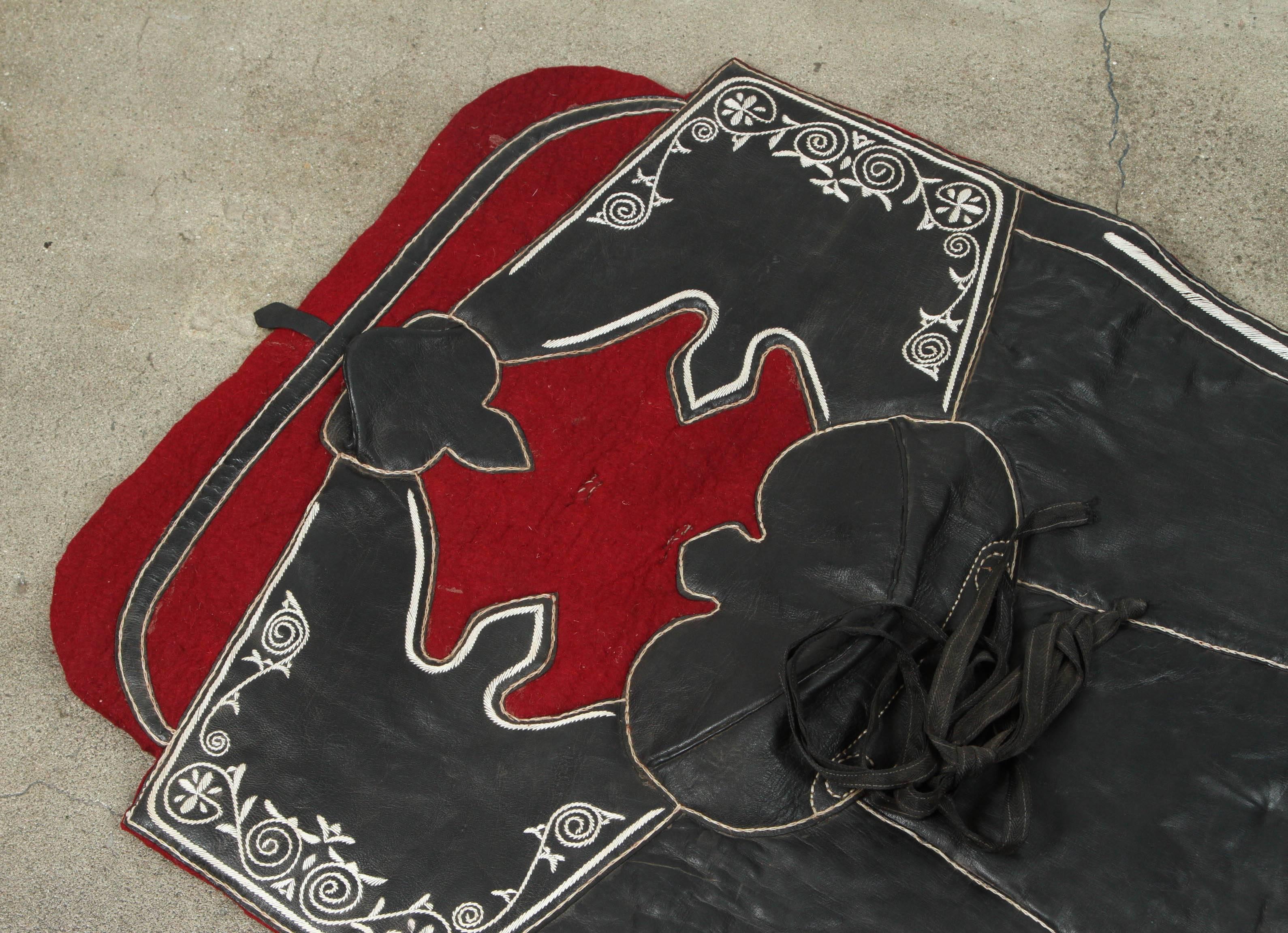 Handcrafted Moroccan horse Saddle pad or blanket, made of black leather, made for a ceremonial Festival and shows.
The central section of the saddle pad is made of black leather embroidered with white threads.
Great to use as a display piece of