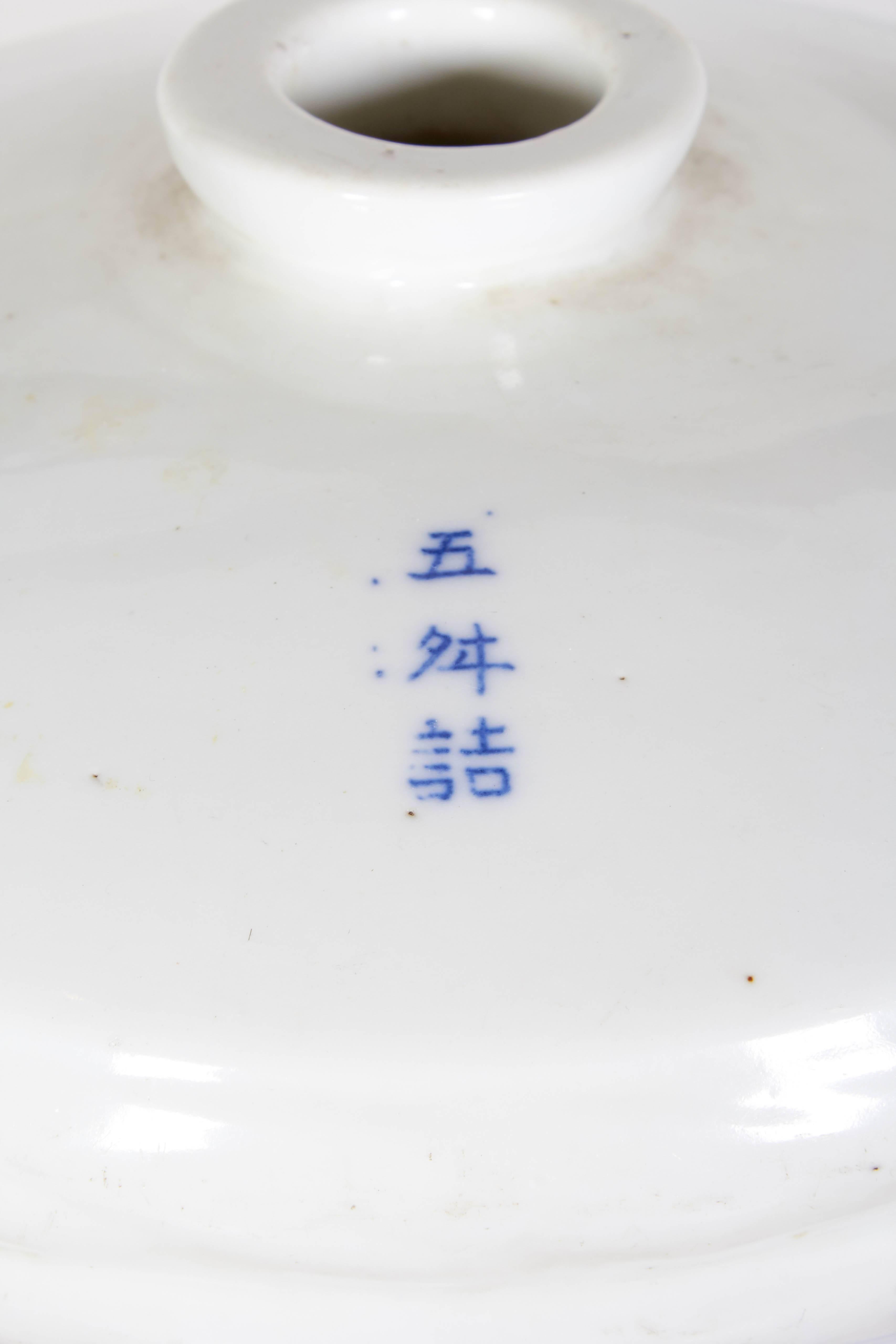 An early 20th century Chinese wine jar made out of thick, heavy porcelain with attractive blue decoration in front and Chinese characters on the back. 
CR752.
