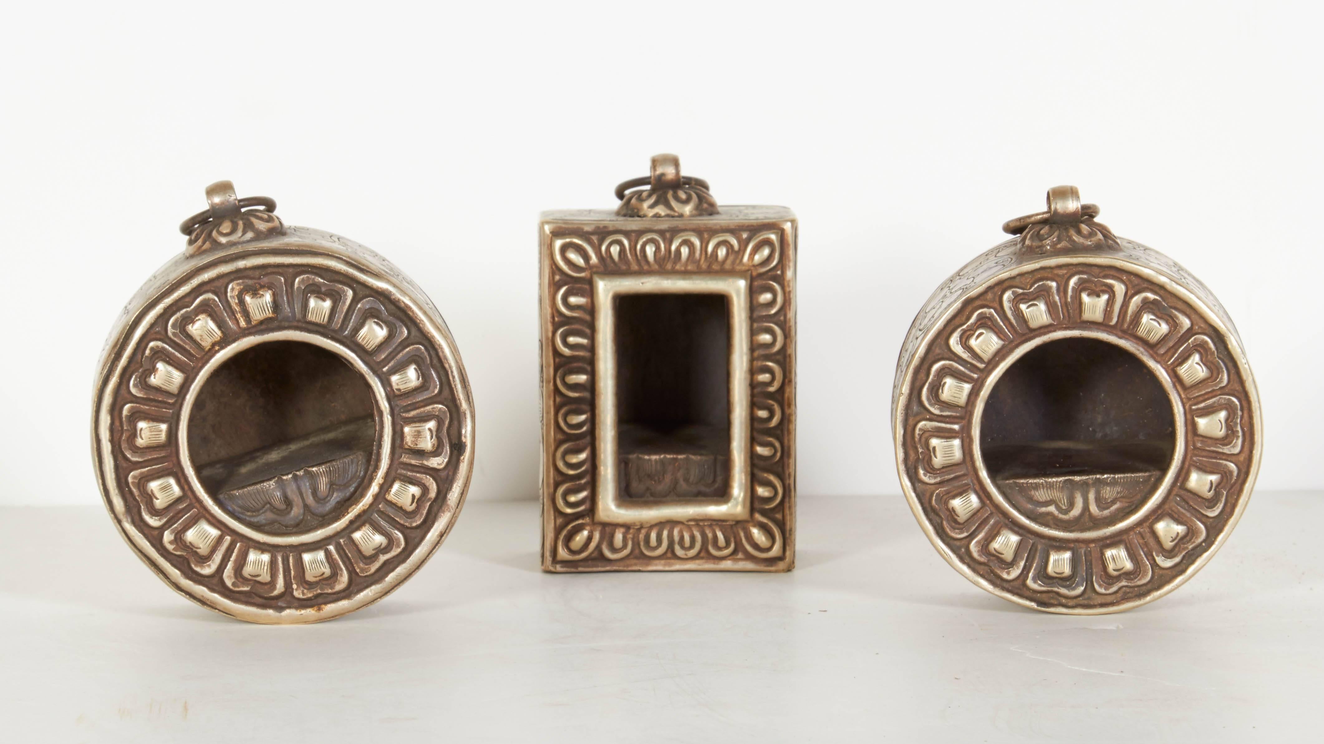 Three antique Tibetan Buddha shrines or prayer boxes (also known as Gaus). These three pieces are all beautifully engraved on Tibetan silver (an alloy of copper and small amounts of silver). These were used as traveling shrines or amulets carried on