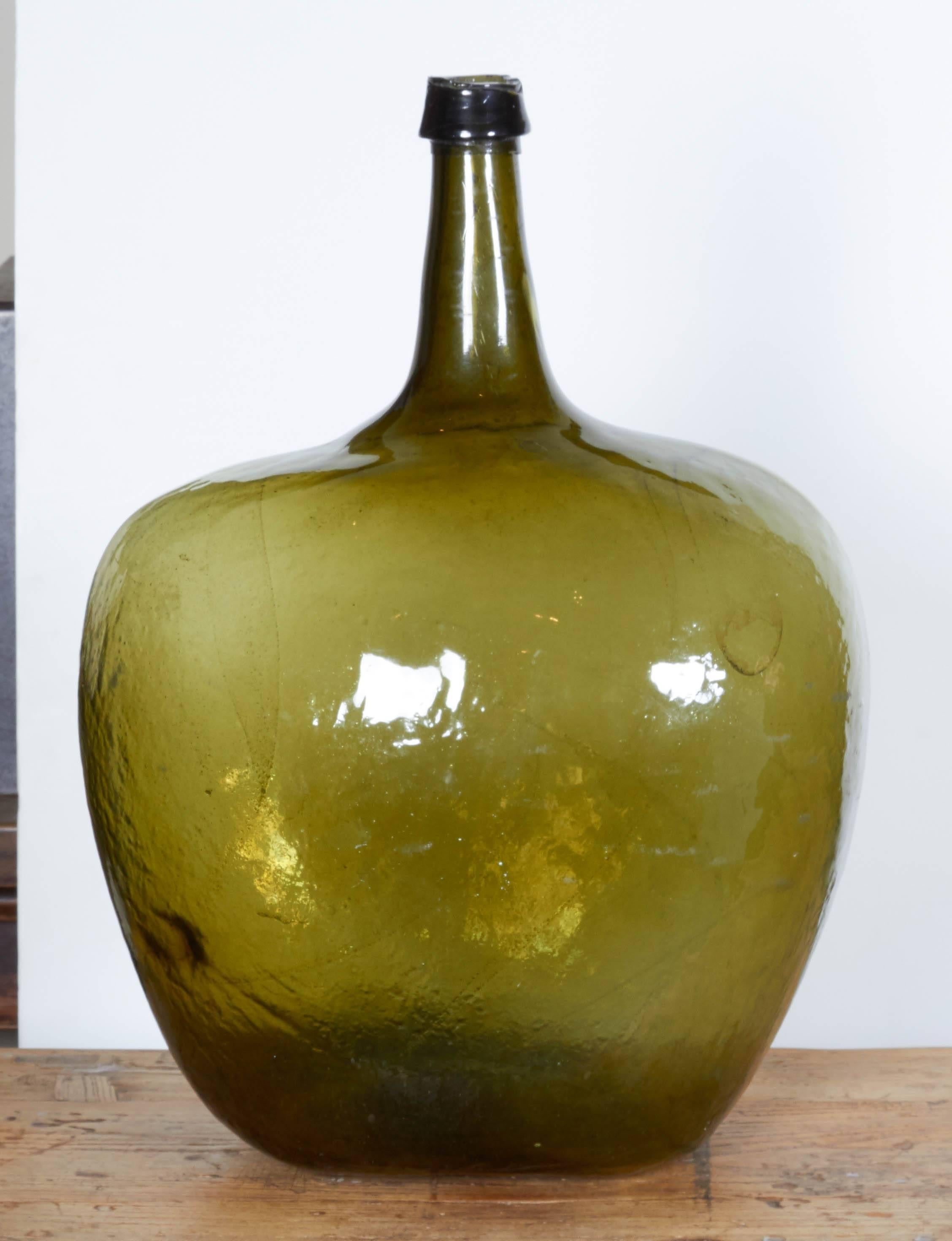 Two beautifully shaped blown glass 19th century demijohns with rough pontils and applied lips. Striking green color, USA, circa 1880. Only one piece  available.
GL217.