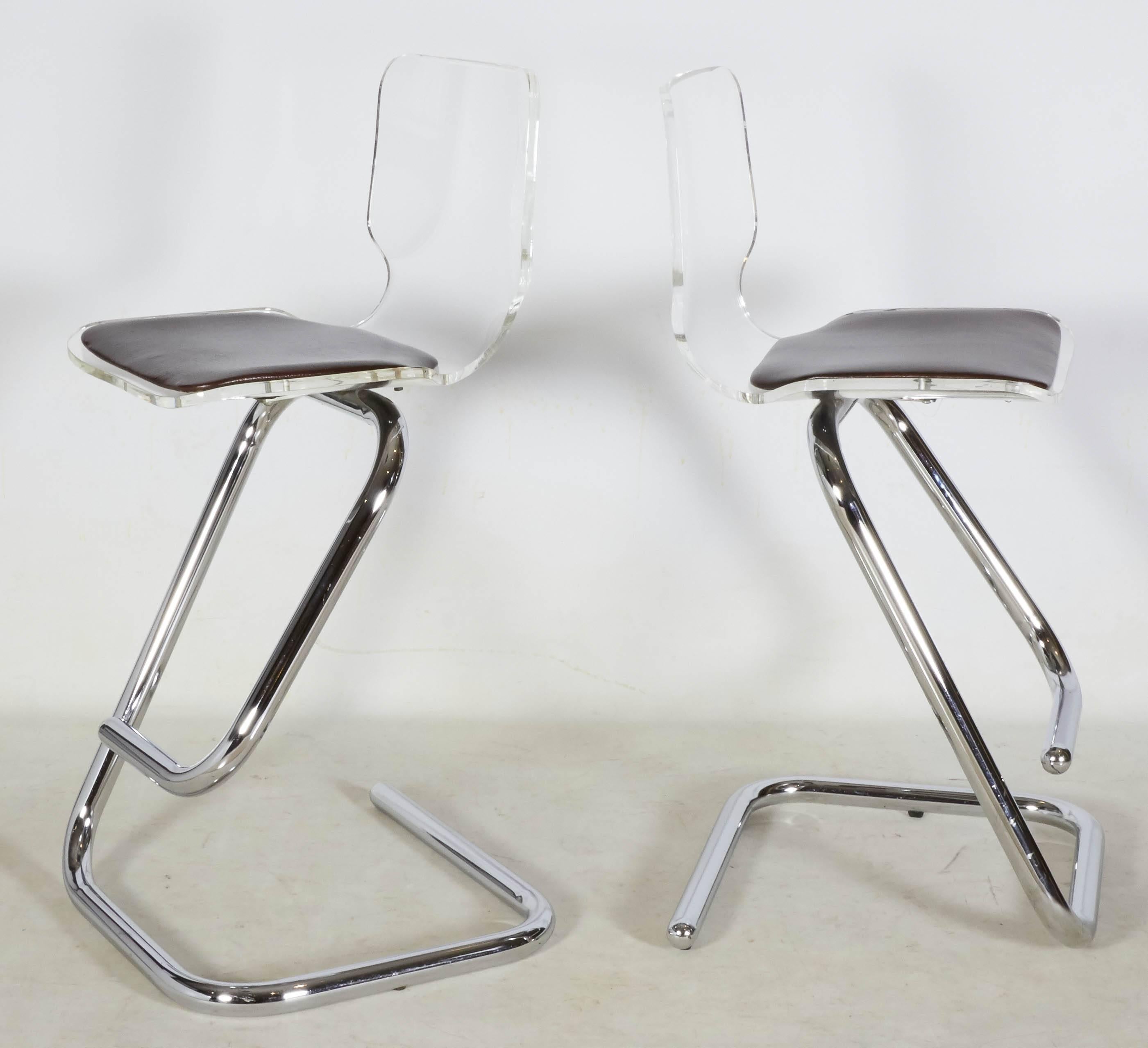 Graceful, modernist Lucite bar stools with sculptural chrome bases. The seat pads are a dark brown vinyl with a faux alligator pattern. There is an additional matching pair available, please inquire. Please contact for location. 