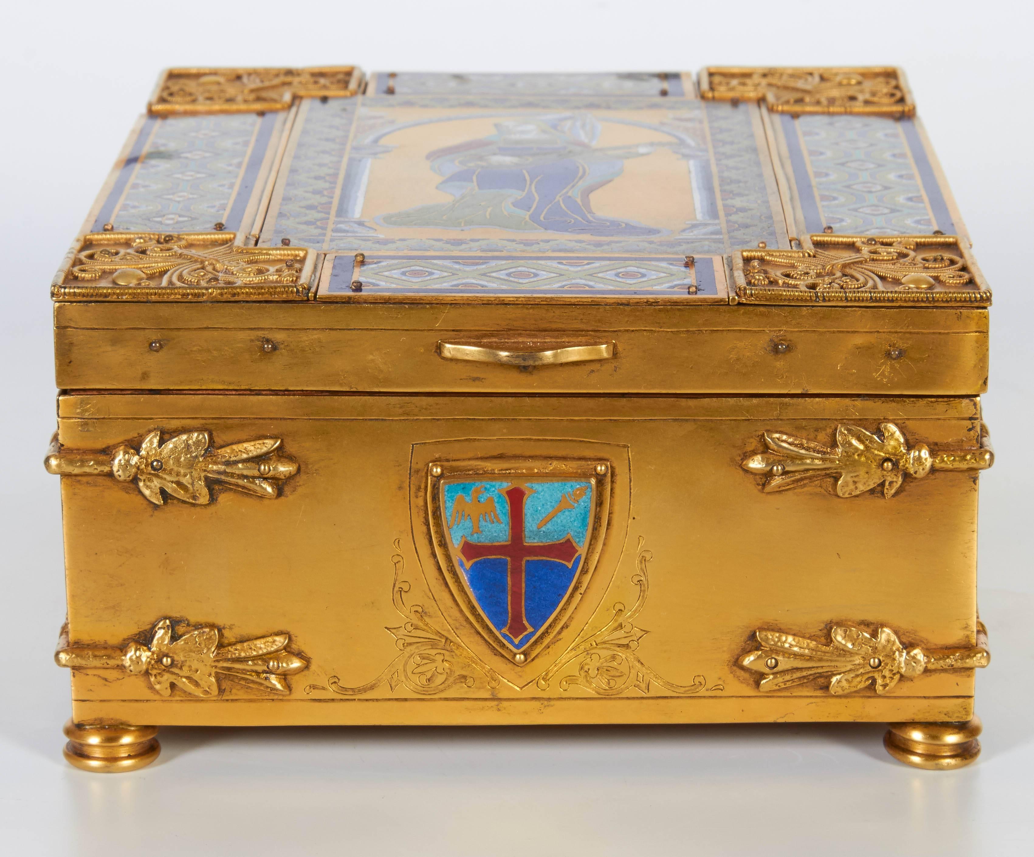 An American Gothic Revival bronze and enamelled box/humidor.
By Edward F. Caldwell & Co. Inc., New York, first quarter of 1900s. 
The rectangular hinged top decorated with a lady playing a guitar, opening to a box finely lined with special wood to
