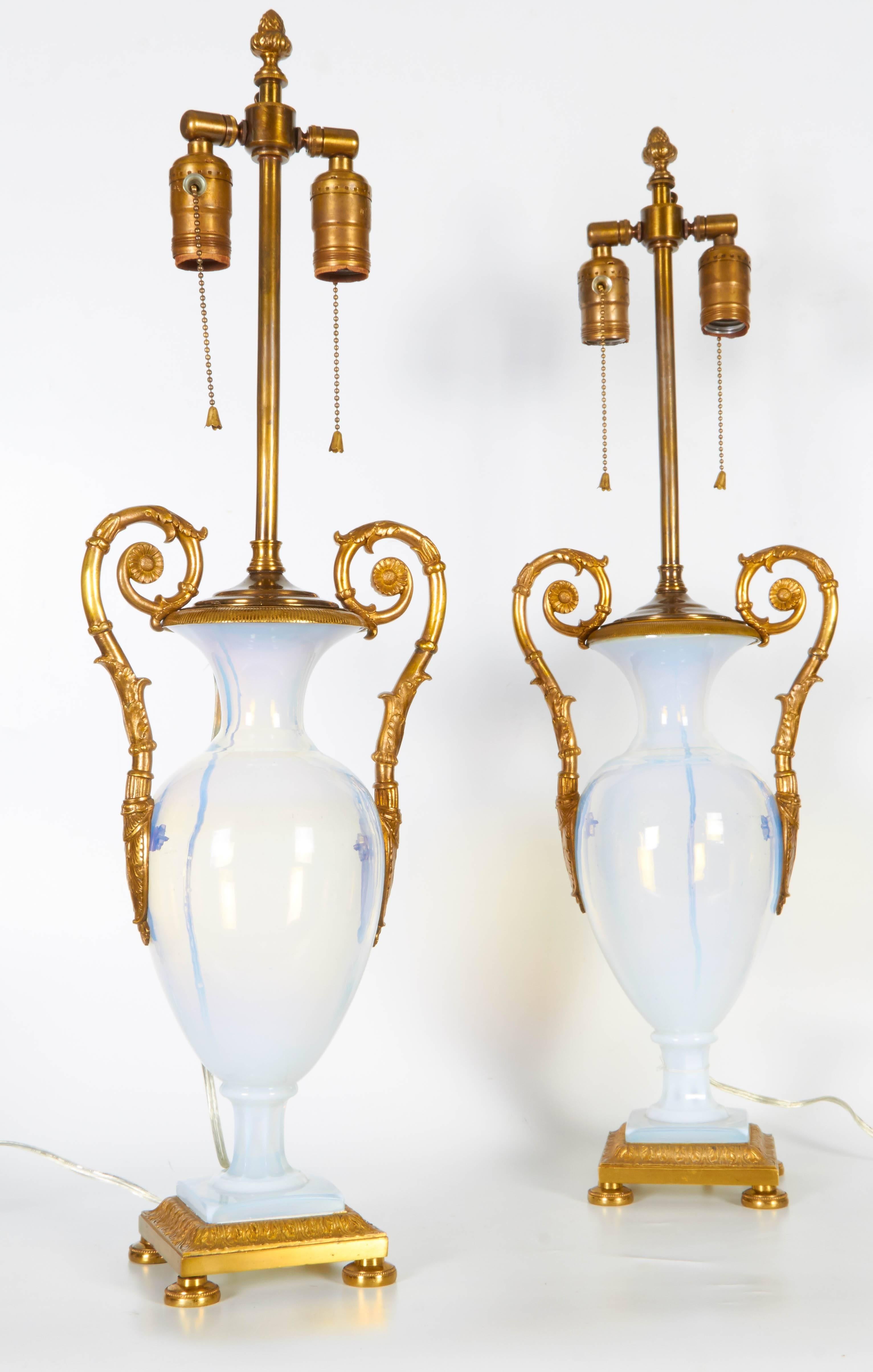 A fine pair of antique Russian neoclassical period white opalescent glass and ormolu mounted two handled vases, later turned to lamps. The electrification was done on the outside and the vases were never drilled, as they are still intact and in