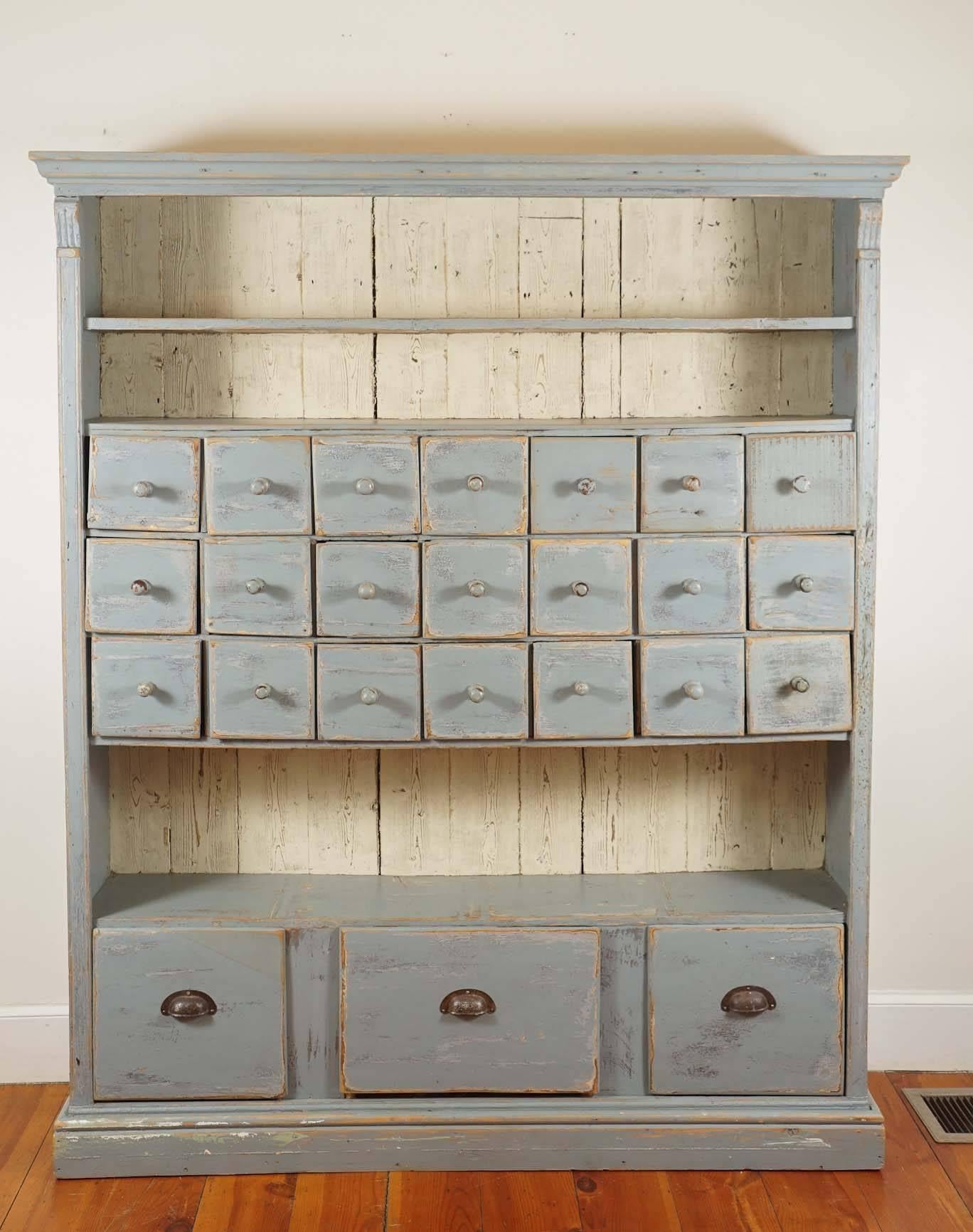 This unique cupboard has it all. Open shelves, 21 apothecary drawers in the middle and three deep useful drawers on the bottom. Combine that with a French blue/grey paint and this becomes one of the more special pieces at painted porch. Bet you