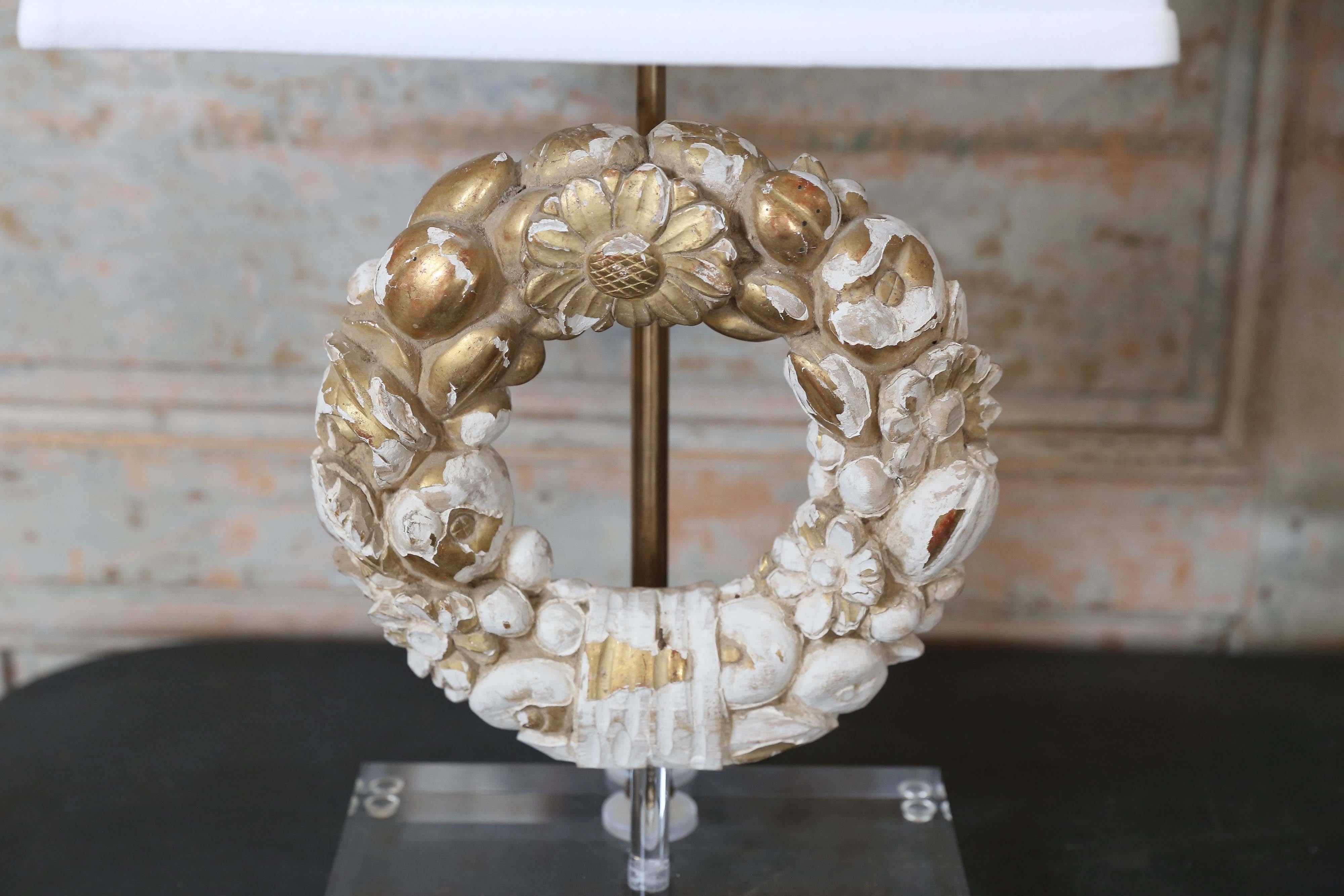 Giltwood wreath fragment table lamp on Lucite base, hand carved Italian giltwood architectural fragment (circa 1840) newly-wired for use within the USA as a custom table lamp. Sold with a complementary linen shade (measurements include