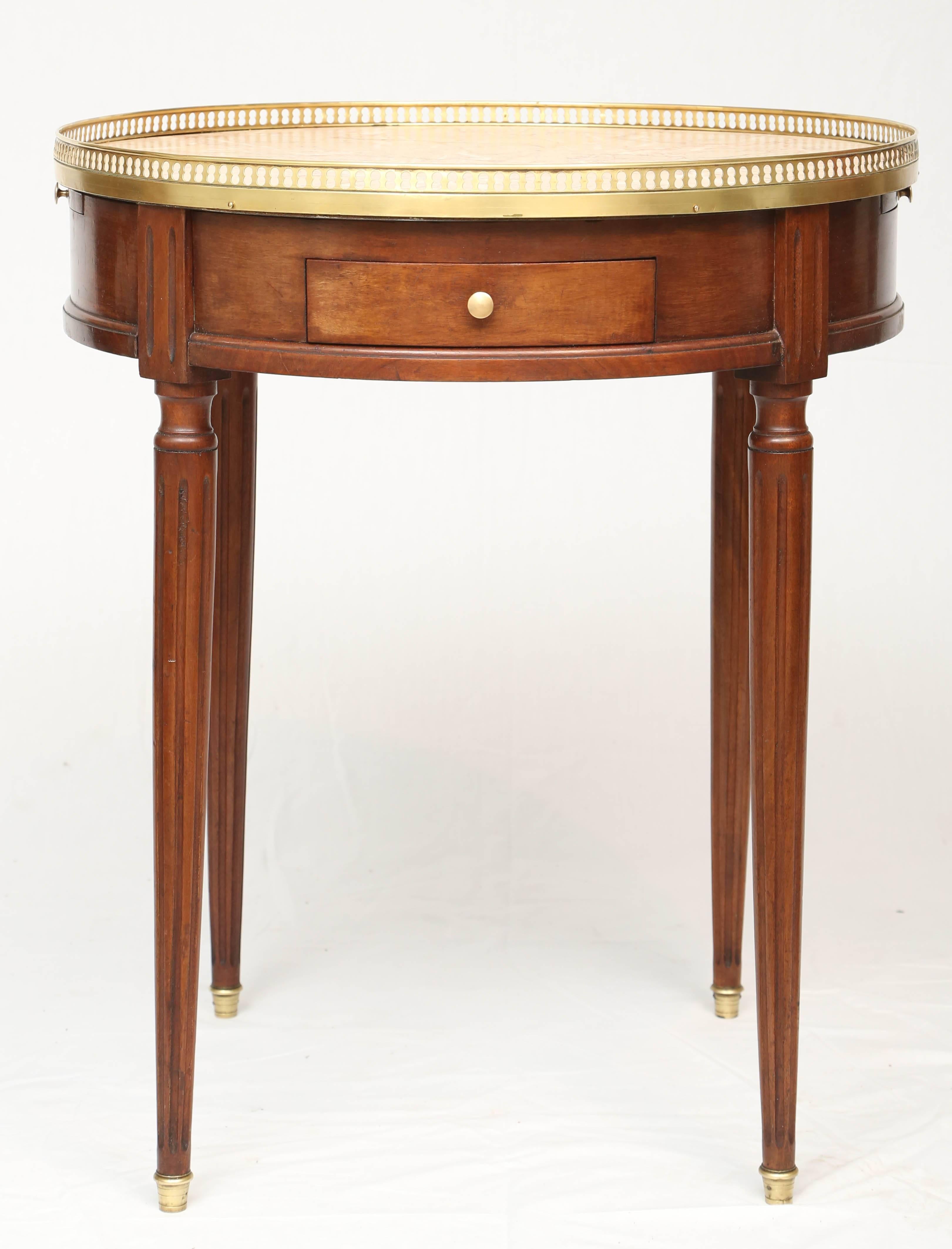 Bouillotte table, having a round top of marble, pierced brass gallery, over double frieze drawers and slides, raised on round, tapering, fluted legs and ending in brass cups.

Stock ID: D9347