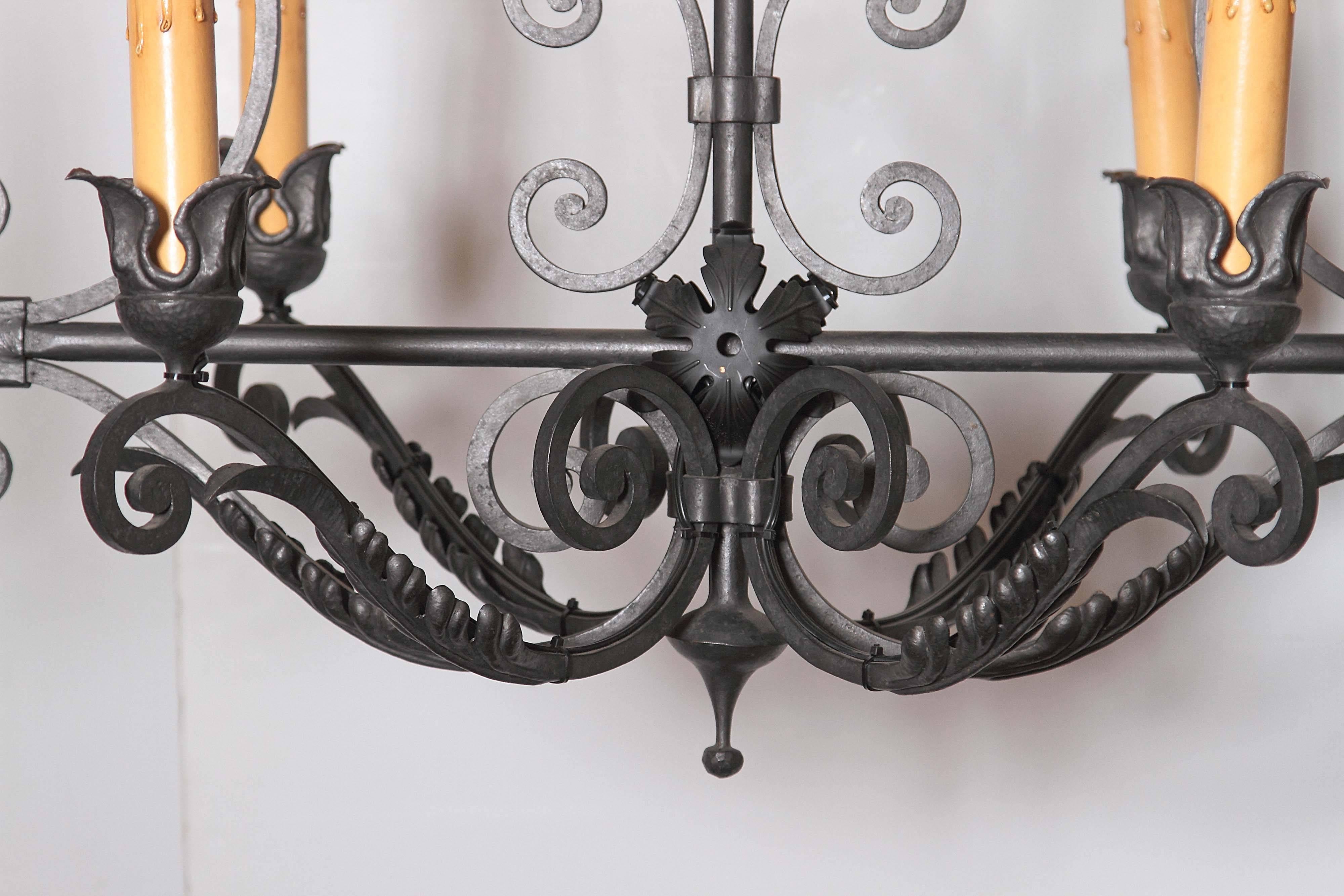 This elegant chandelier was crafted in France, circa 1950. The light fixture has six lights and a symmetrical, rectangular shape with scroll design. This neutral gray and black fixture has been rewired and would enhance the appearance and lighting