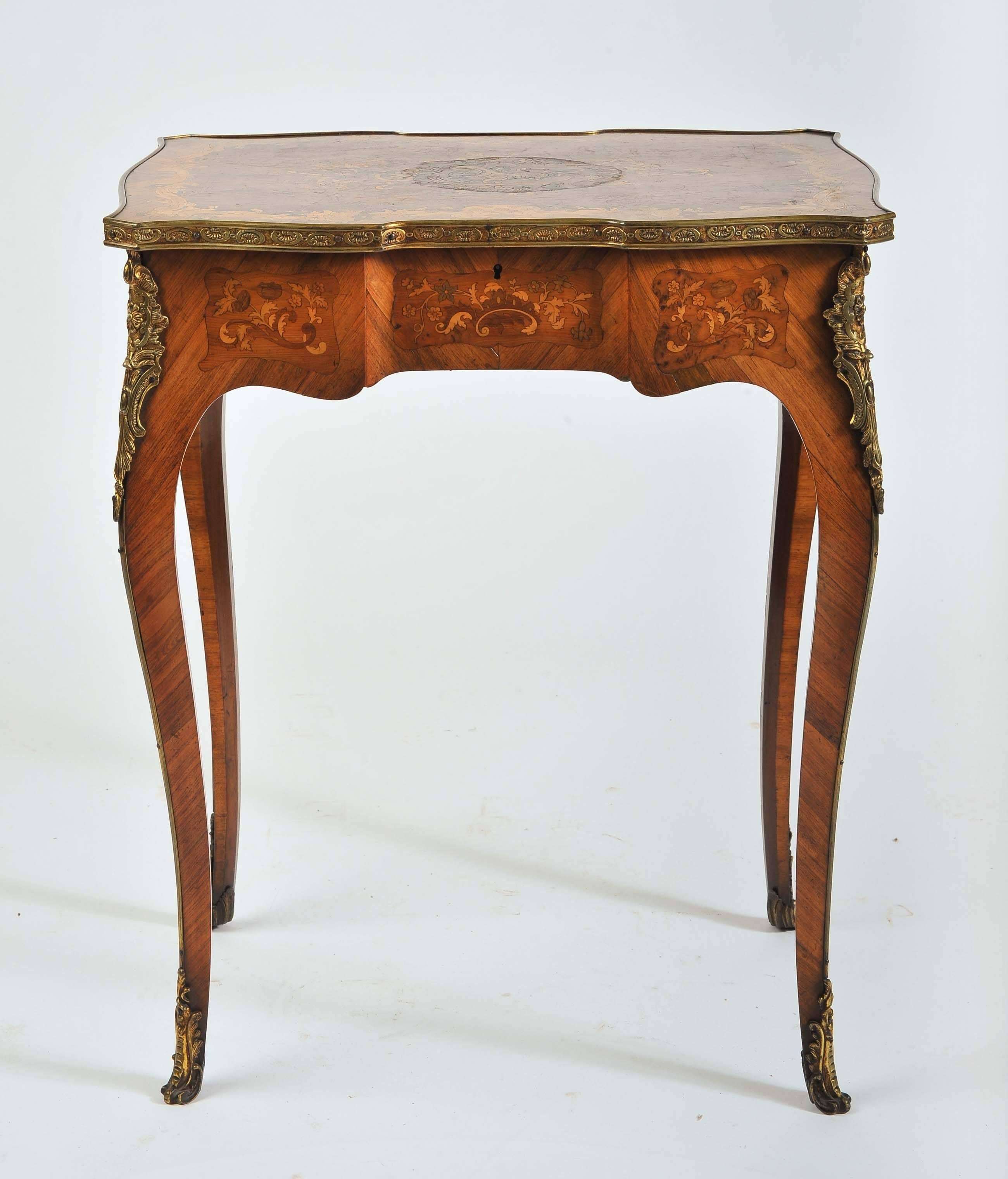 A fine quality 19th century French marquetry inlaid side table, having swag and foliate decoration, gilded ormolu mounts and raised on cabriole legs. The top hinged to reveal a storage compartment.