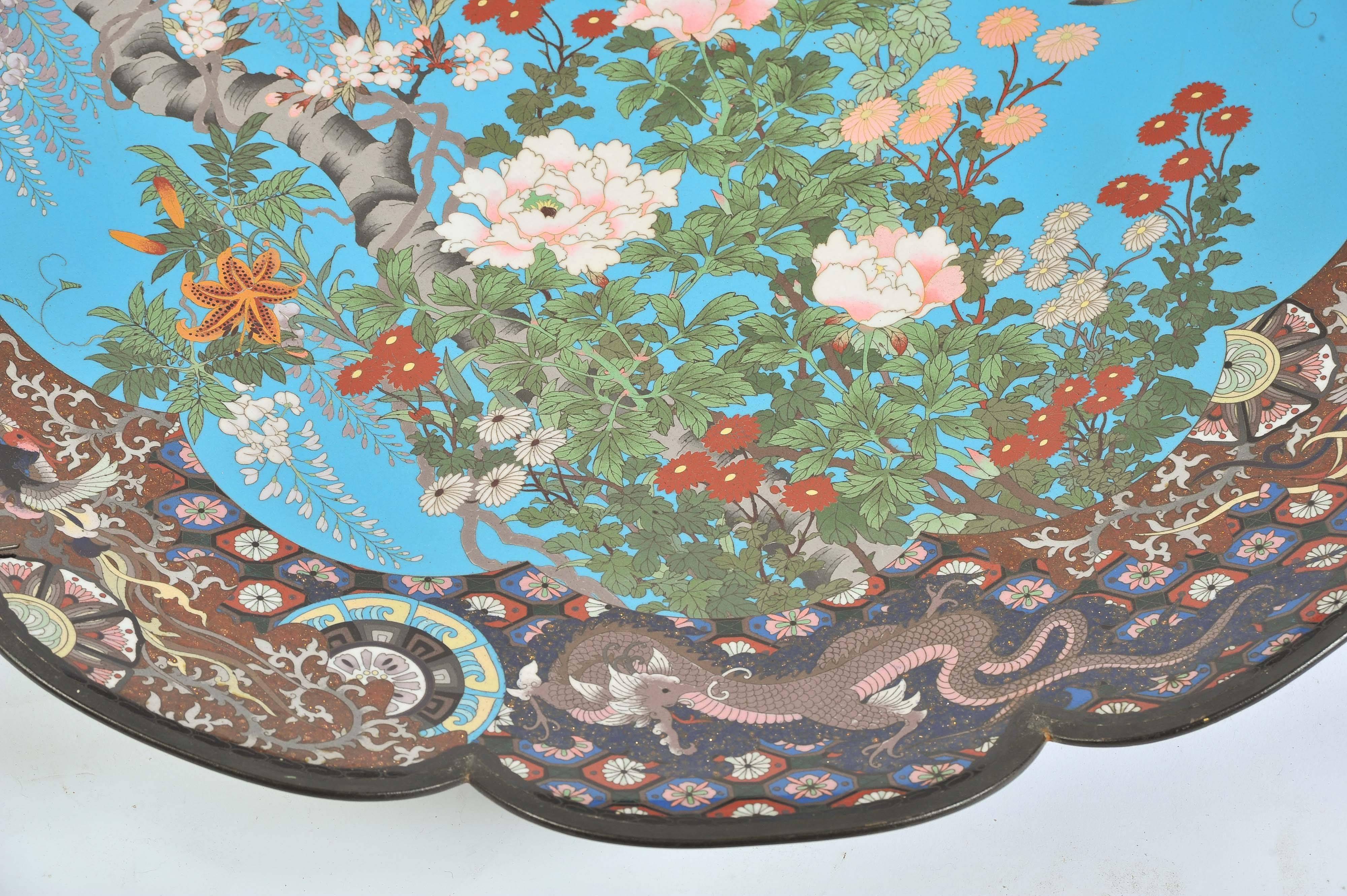 A very impressive large Meiji period (1868-1912) Japanese cloisonné enamel charger. Having a scalloped edge, the margin depicting mythical dragons and birds amongst various classical motifs and foliage. The centre with a large eagle like bird flying