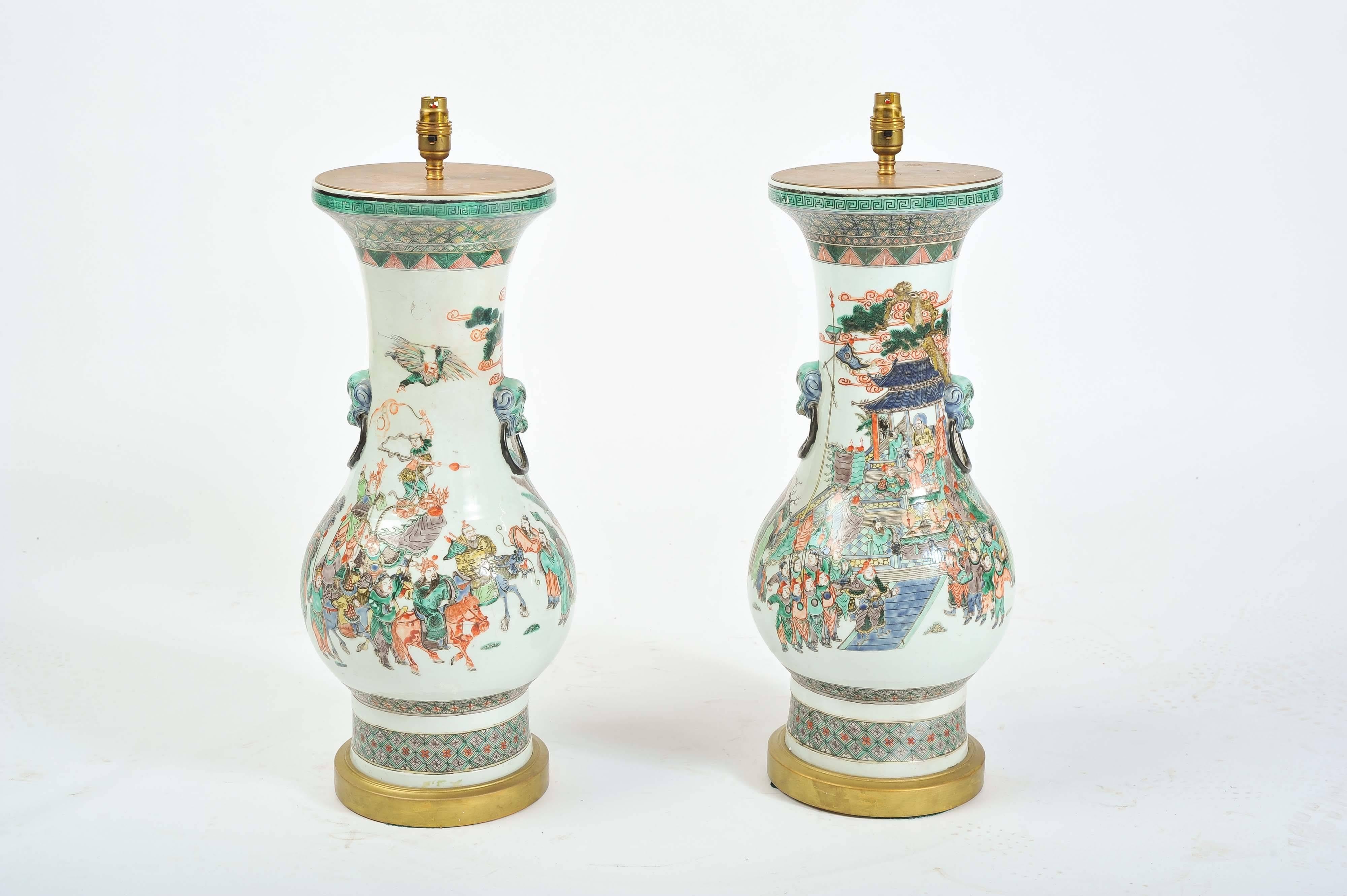 An impressive pair of Chinese 19th century Famille Verte vases/lamps. Depicting classical warrior scenes, mounted on giltwood bases.