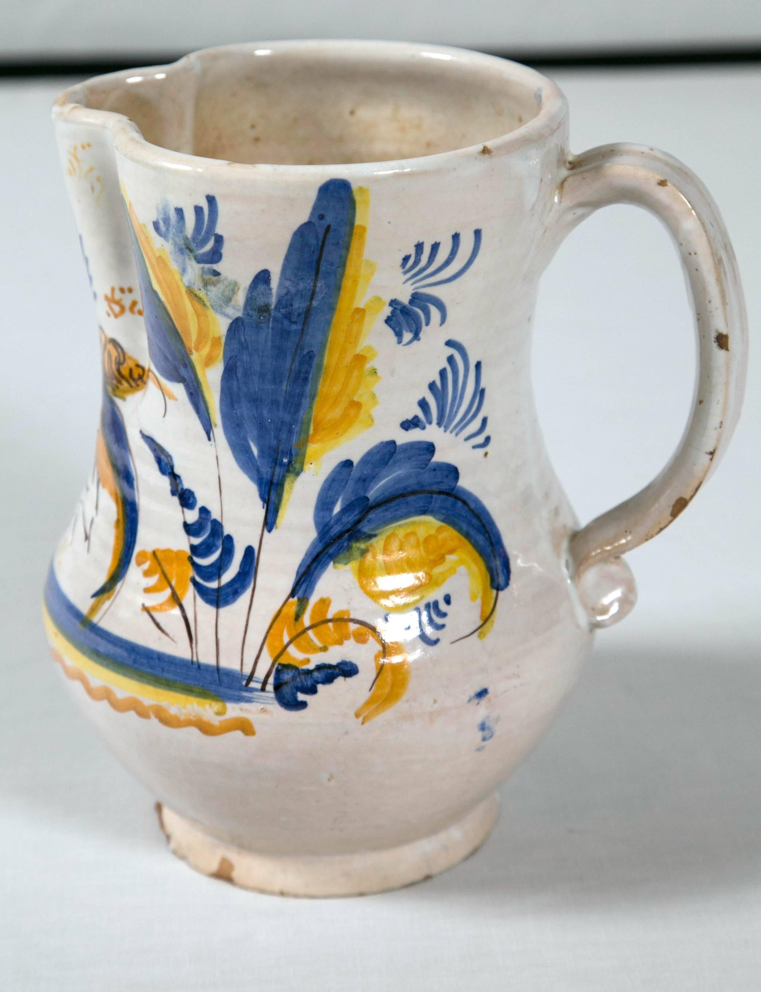 French Faience pottery pitcher, circa 1900. Charming hand-painted blue and yellow design typical of the south of France. Stylized bird and foliate motifs.