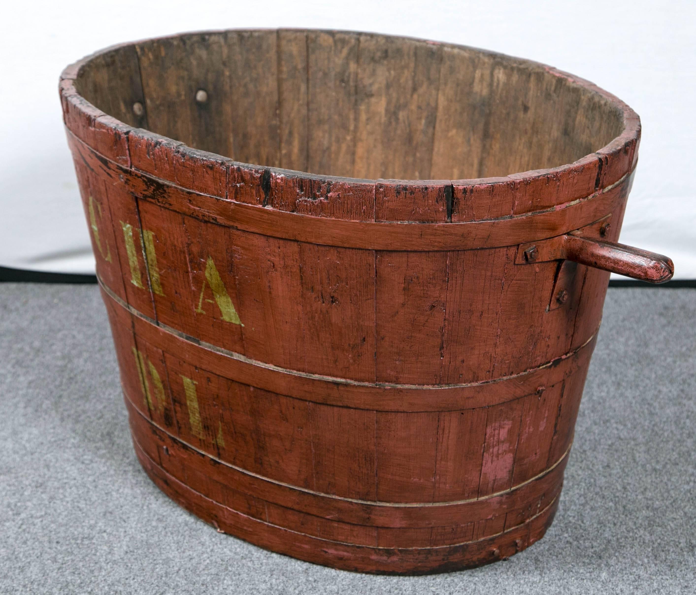 From the vineyards of France, a charming wooden staved bucket with iron handles and rings. This was used to gather grapes. The iron handles would be hooked onto wheeled carts. Stenciled letters 