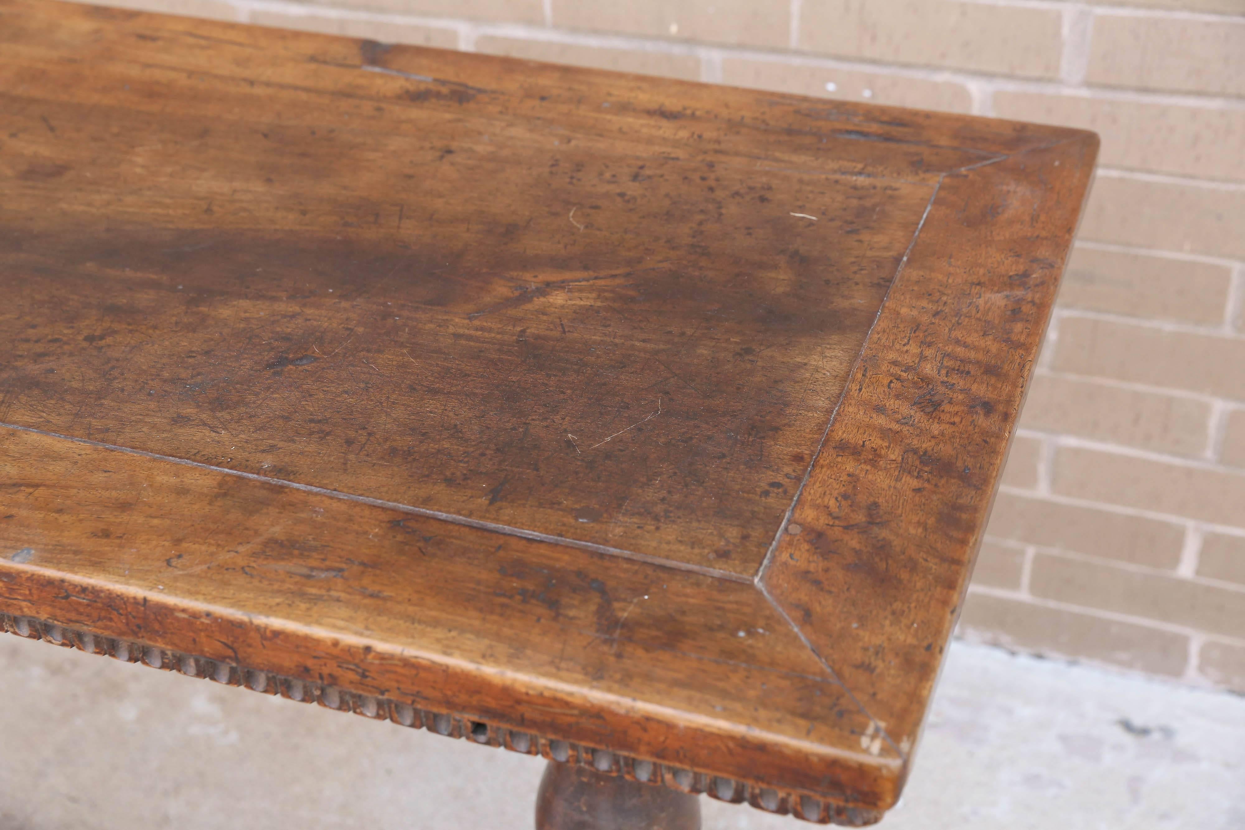 Italian handsome walnut console with carved skirt all the way around. This is all original and has a beautiful patina.