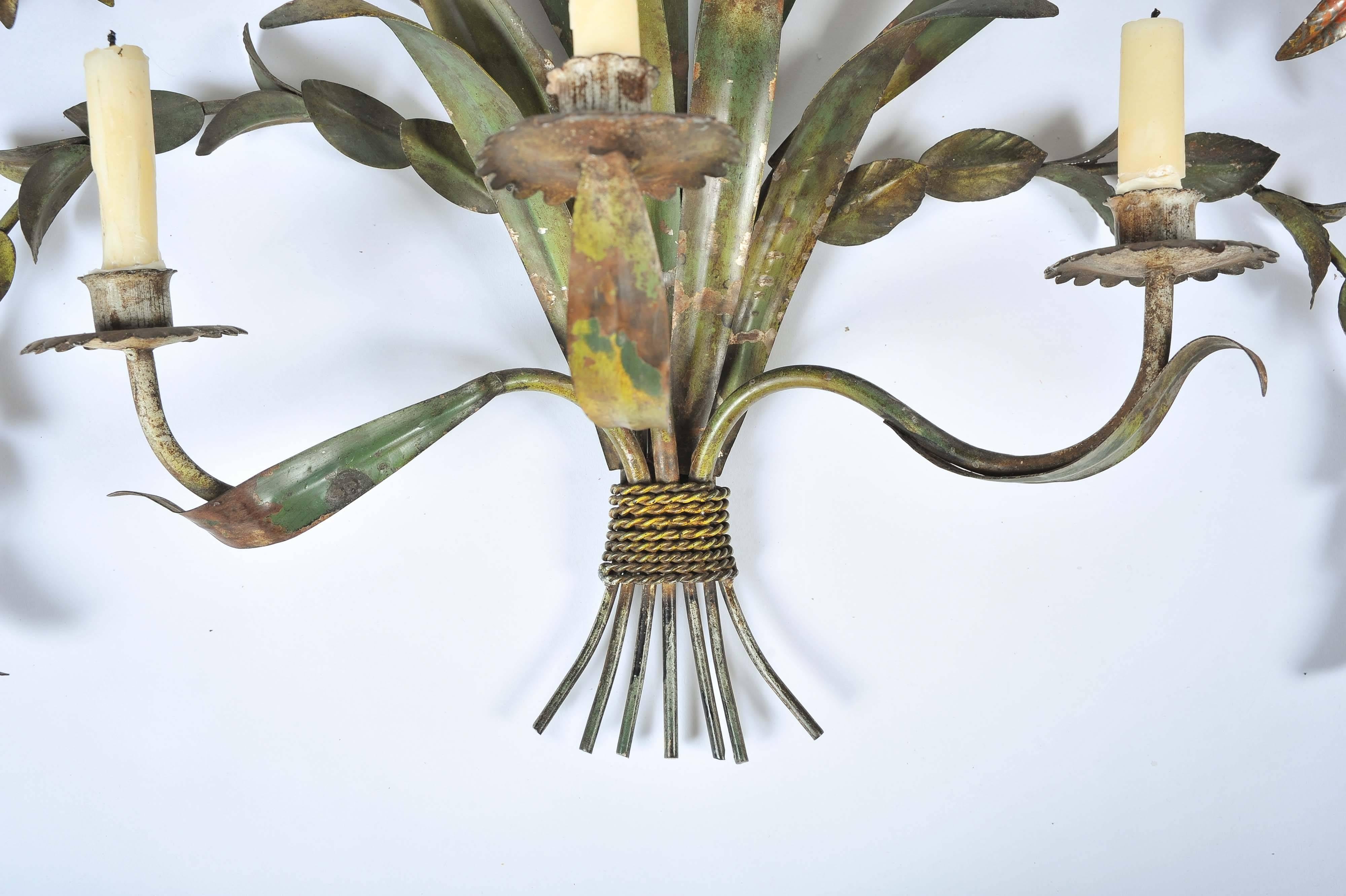 A most unusual and highly decorative Colonial painted toleware wall sconce in the form of a spray of five flowers and foliage with three candle branches.