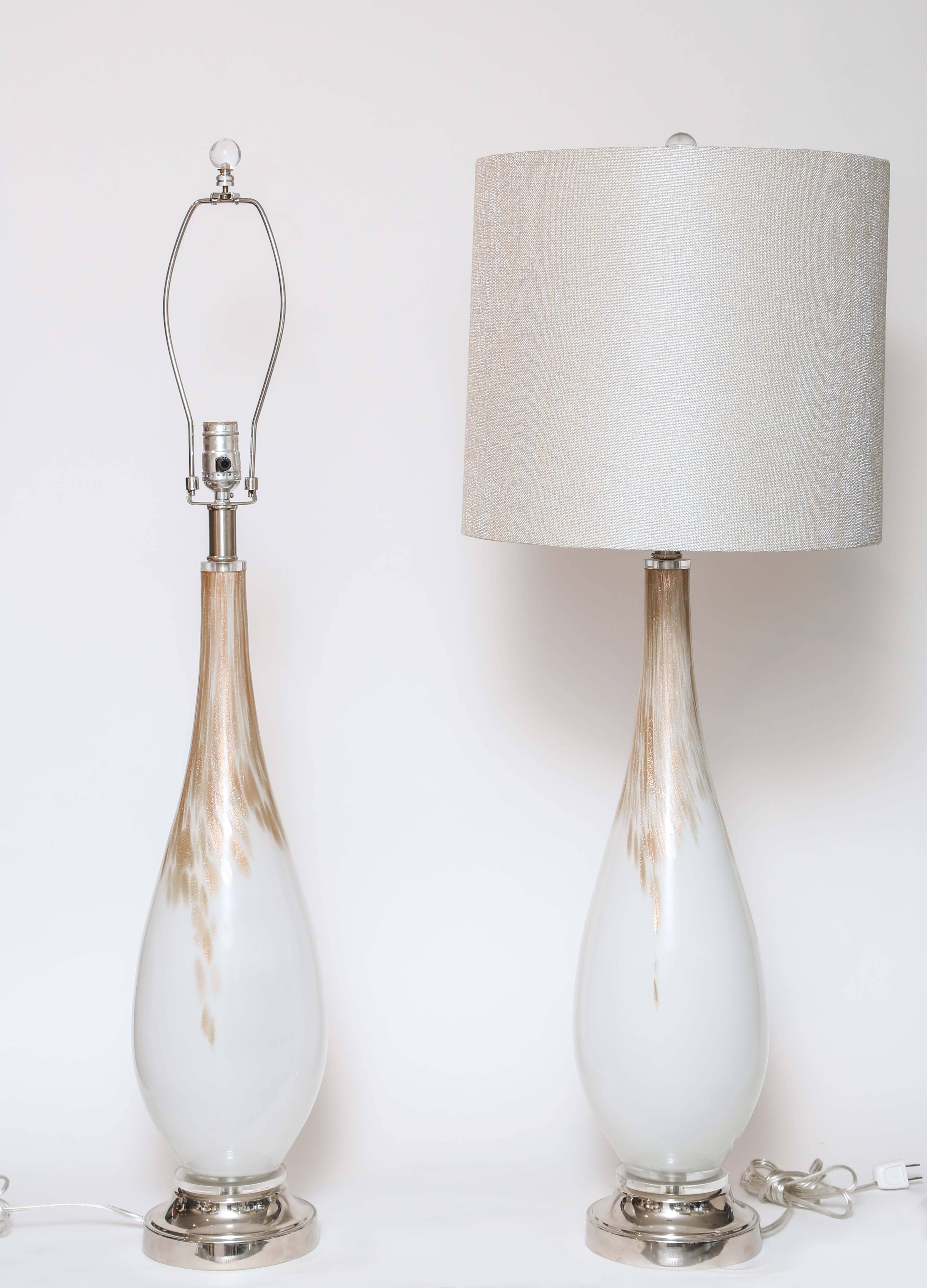 Metal chrome base, teardrop shape glass in white with copper flecks running down the neck. Linen shades and clear glass ball finial. These lamps have been refurbished, so they are in very good shape.
