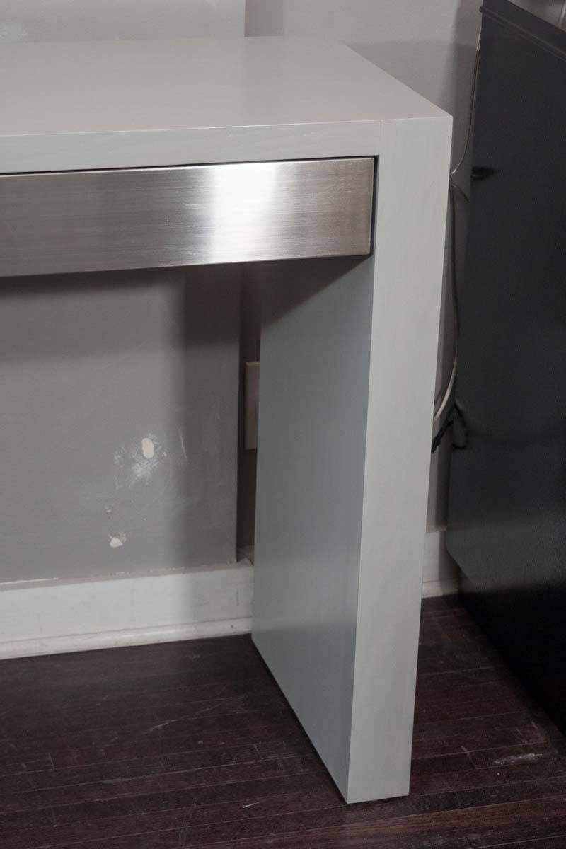 Custom gray stained console with brushed stainless steel drawers.