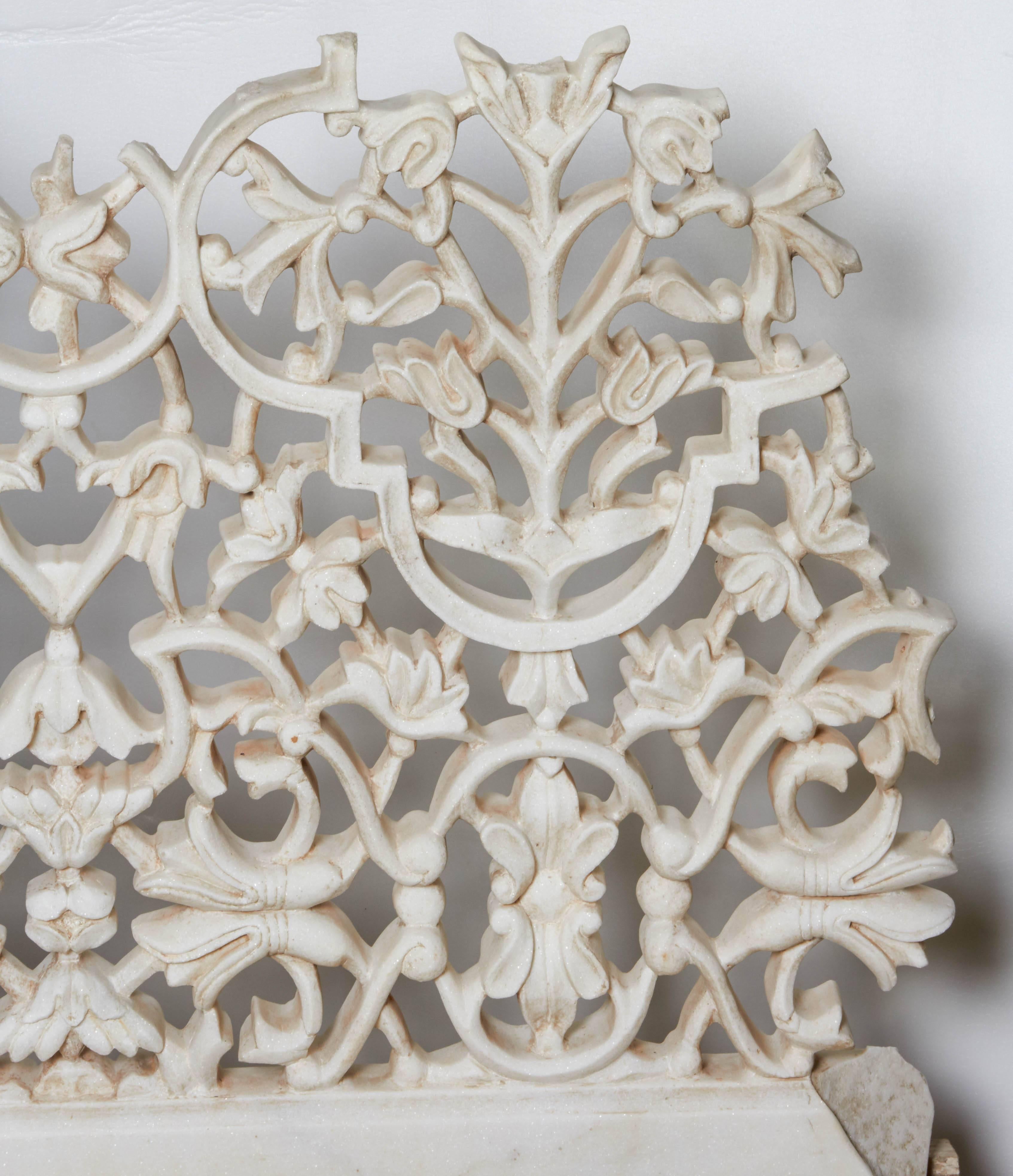 A beautiful white marble fragment of a Classic jali screen lattice from India, with an intricate floral pattern, mounted on a wood base.
