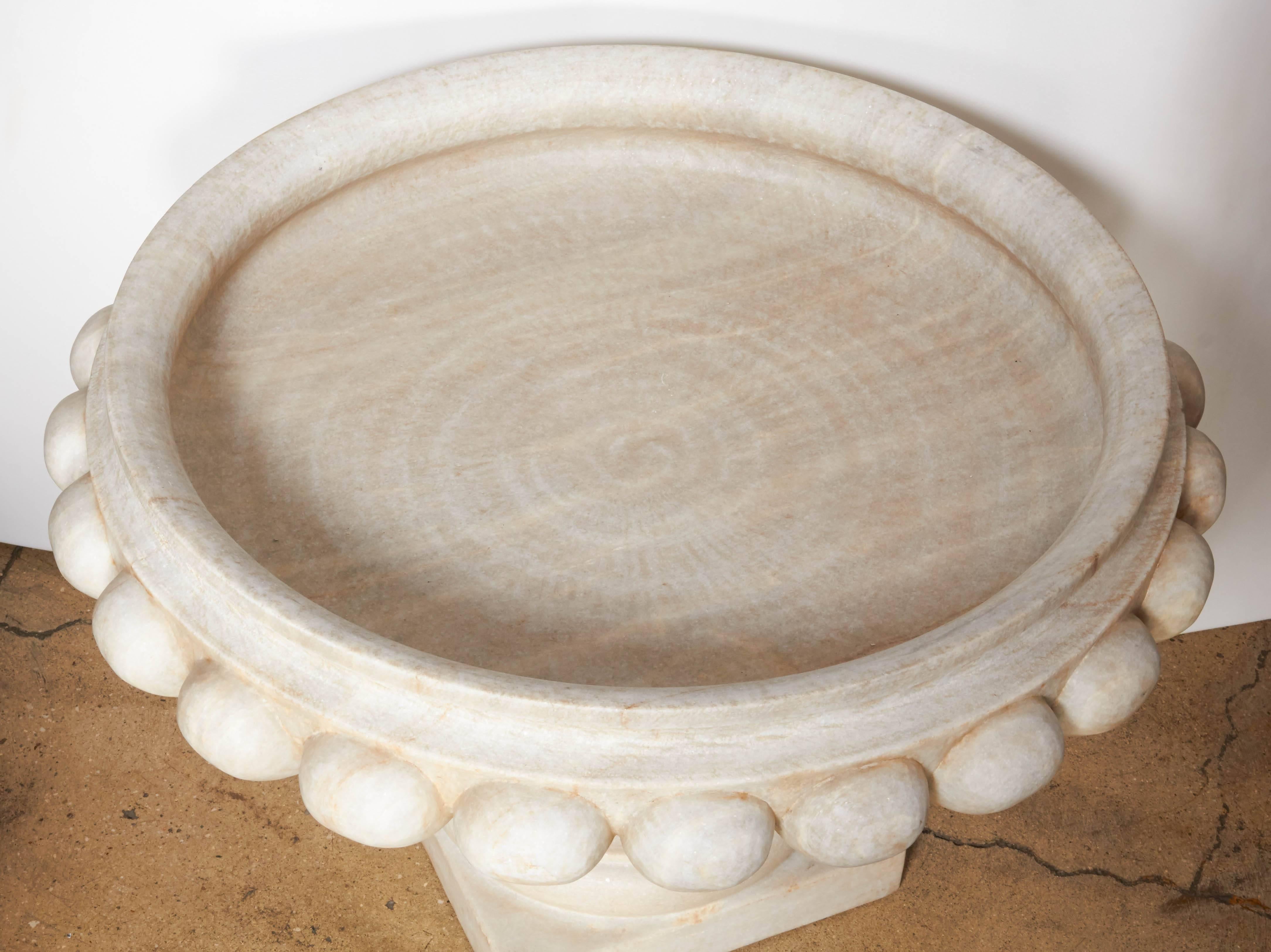 A large marble bowl with decorated rim on a pedestal. A shallow planter, fountain, or pool, for an atrium or garden. Two pieces.