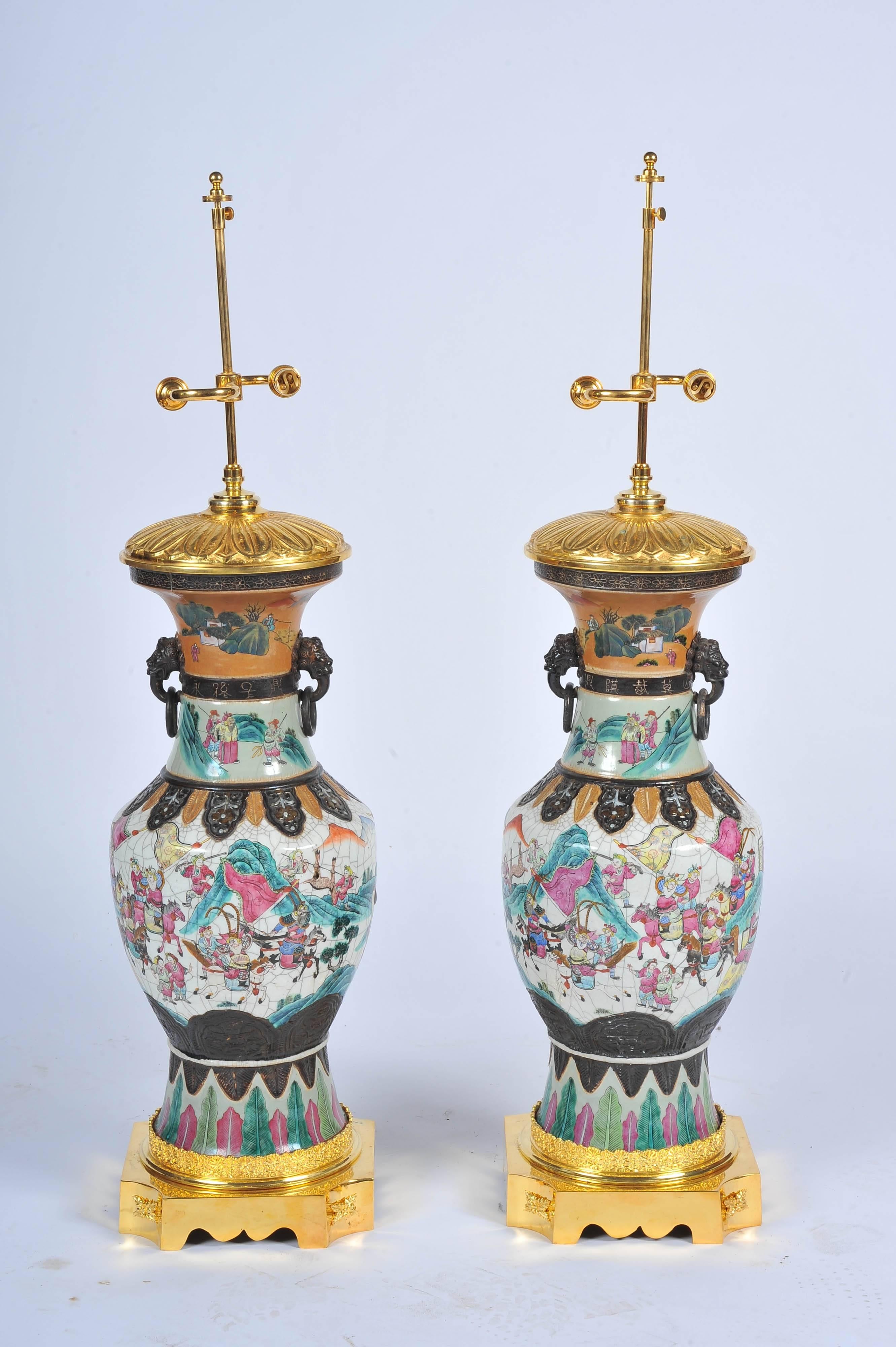 A very impressive pair of 19th century Chinese crackle ware Famille Rose vases or lamps. Each with classical mountainous scenes with men on horse back hunting. Set on gilded ormolu bases and lids.