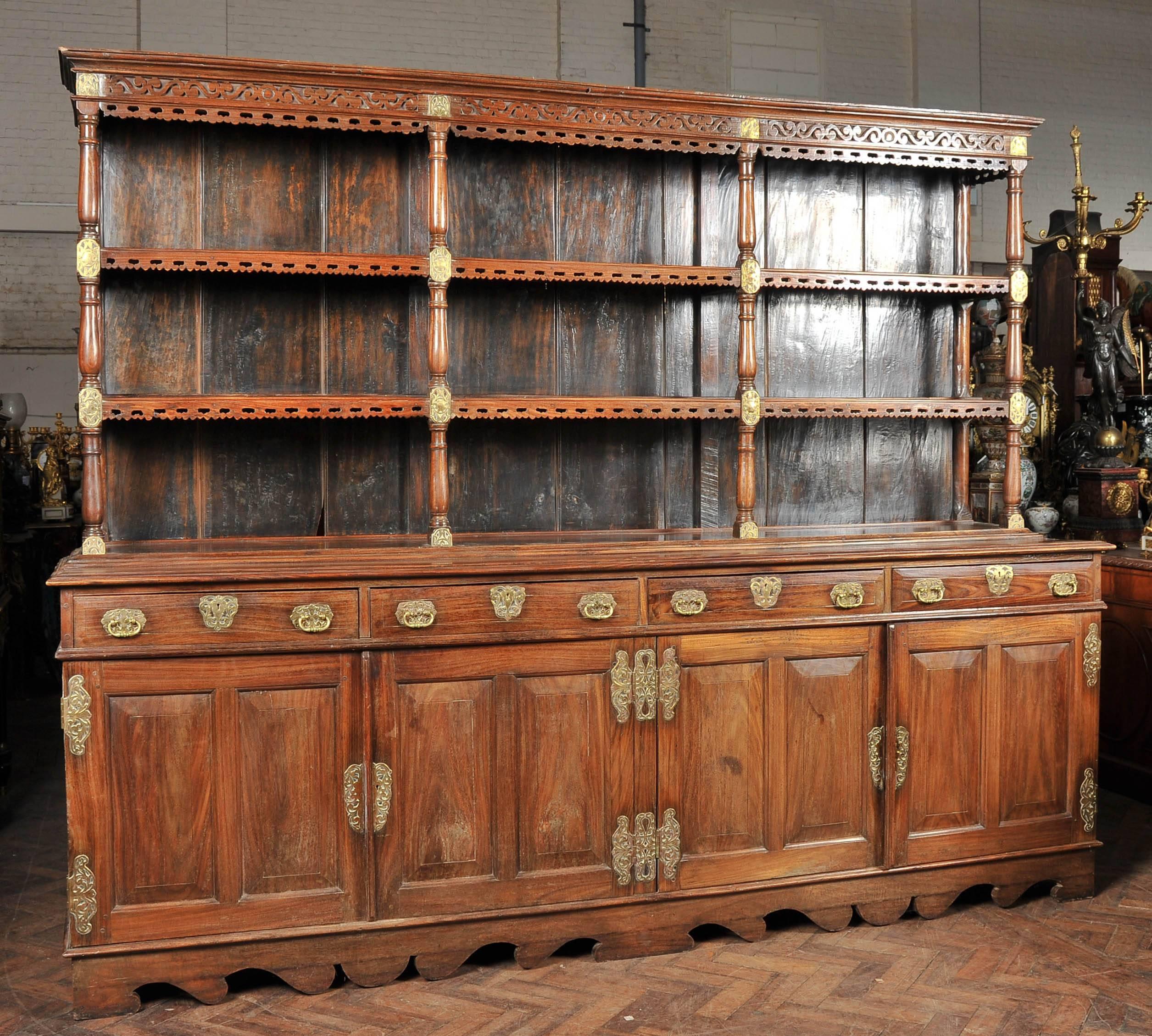 A rare early 19th century Ceylonese Padouk wood dresser, having wonderful brass sunburst and leaf mounts. The cornice with s scrolling blind fretwork above three shelves each with pierced aprons. Above four drawers and four recessed panelled doors