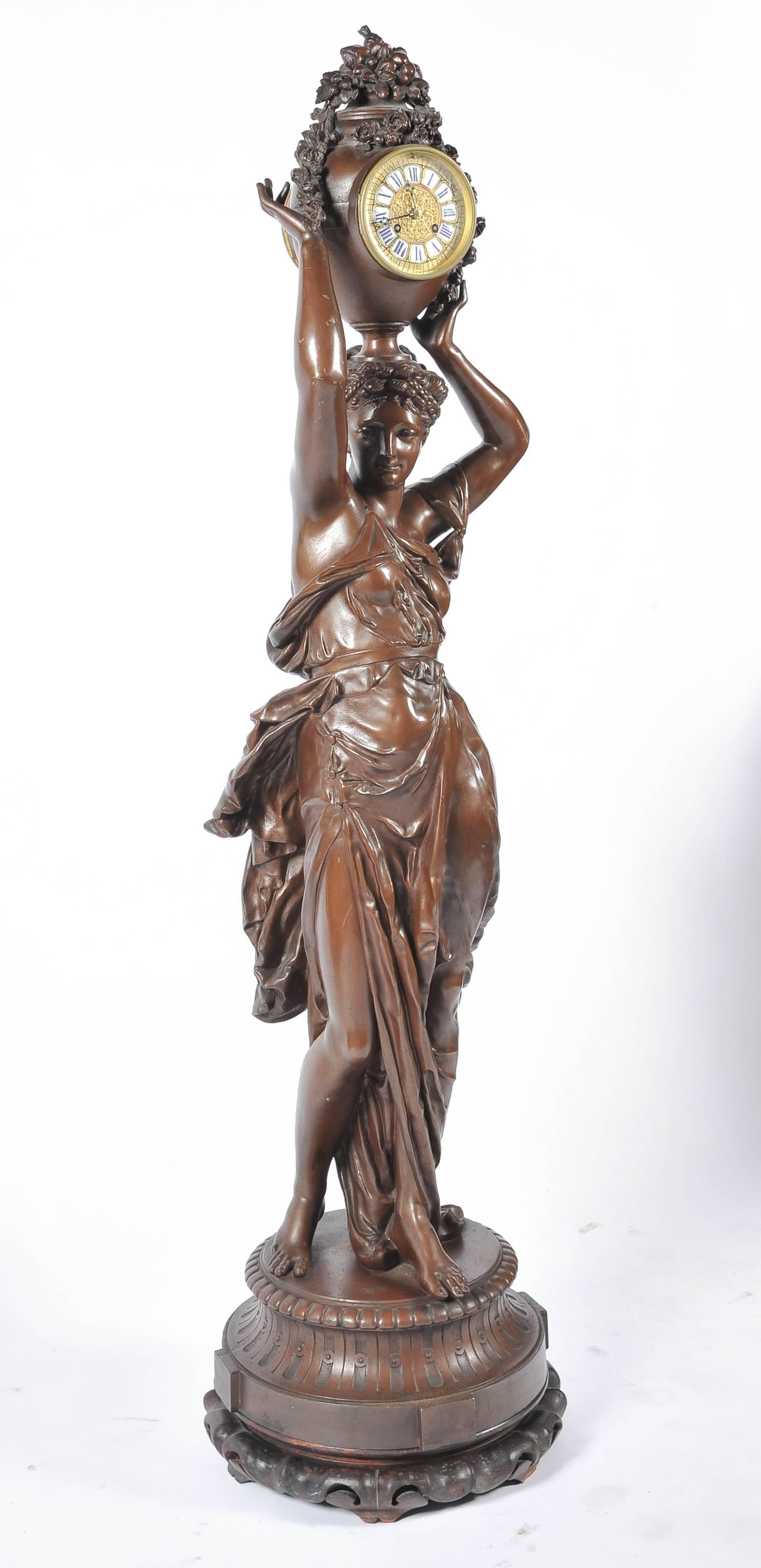 A very good quality French bronzed Spelter mystery clock, depicting a classically draped women carrying an urn with flowers and fruit. The eight day chiming clock set into the urn. 
Model by Albert-Ernest Carrier-Belleuse.