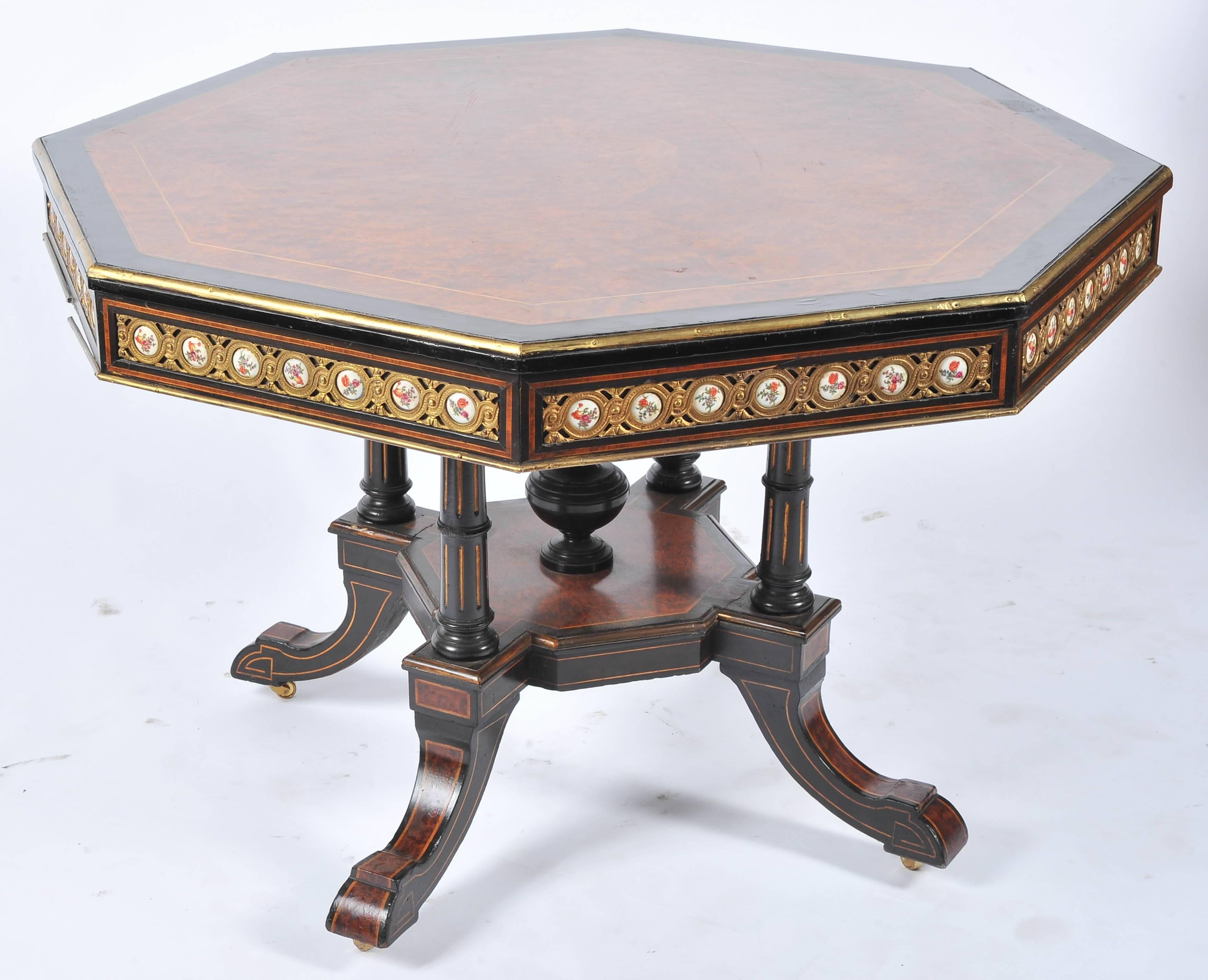 A good quality 19th century English Amboyna and ebony centre table, having French 'Sevres' porcelain plaques inset around the frieze, four turned supports, a platform with central urn and four out swept legs again with inlaid Amboyna veneer.