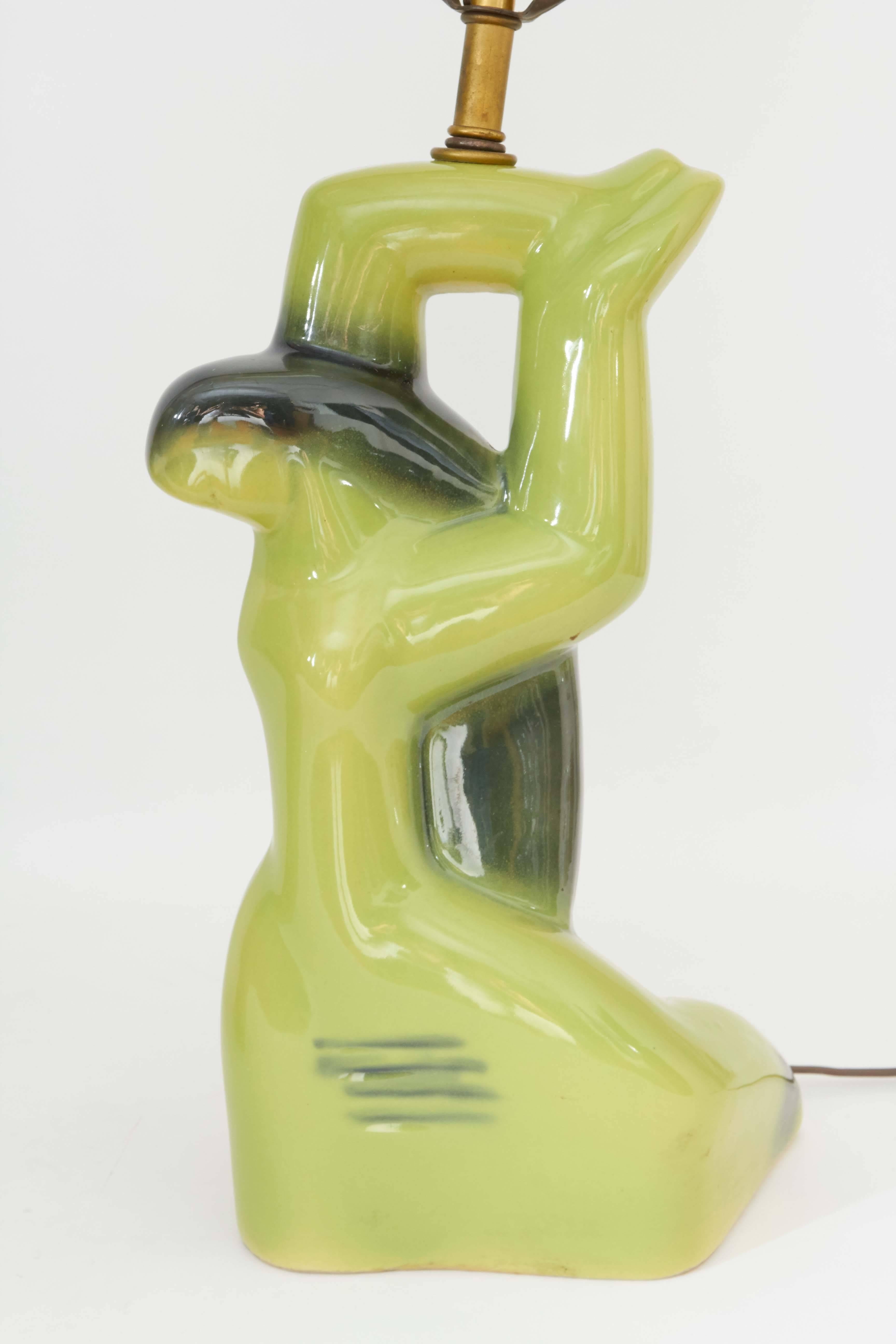 A pair of circa 1950s sculptural table lamps by Yasha Heifetz, depicting the abstracted figures of a man and woman in brilliant green glazed ceramic. Each with single socket, requiring Edison base bulbs. Markings include #2722 impressed to the