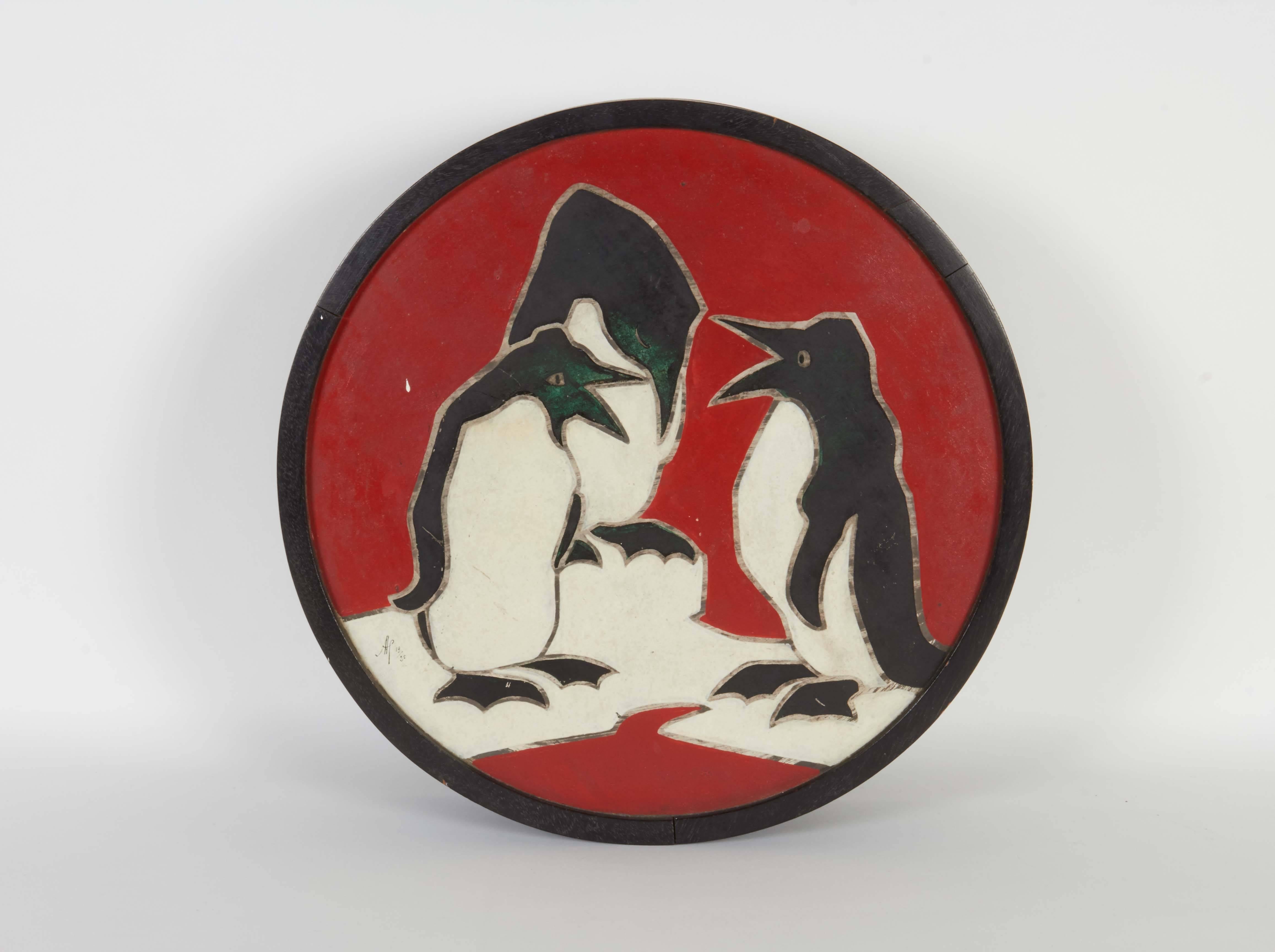 A round lidded box from the Art Deco era, produced in France circa 1920s, crafted of wood, the lid decorated with painted marquetry, depicting penguins congregating. Markings include [AP 19/25] signed to the lid. This piece remains in very good