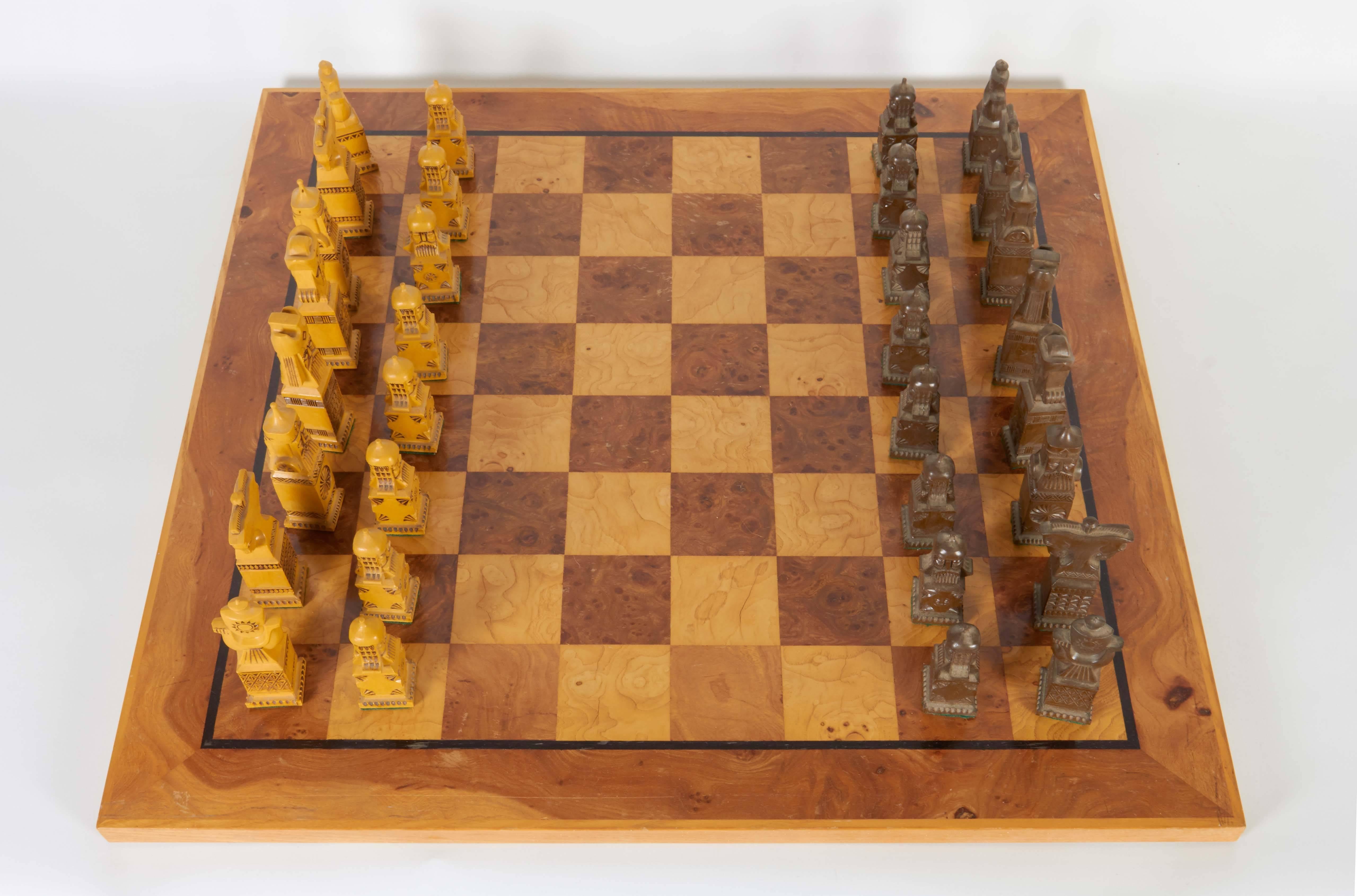 A circa 1970s chess set, including intricately detailed Russian pieces, reminiscent of Folk Art styles, in tan and brown resin, on a burl wood chessboard (produced in the United States); includes original box. Very good vintage condition, wear