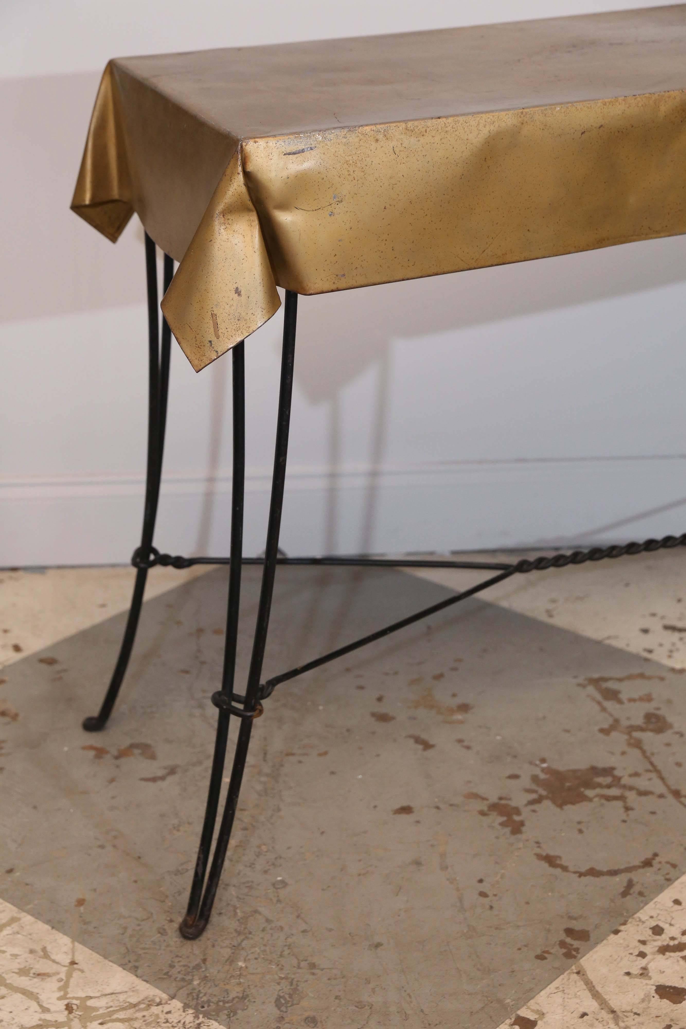 Vintage French console table discovered in Chartres, France. We just love the slender iron base of this Mid-Century design with the faux linen top crafted in painted metal.

Measures 47.5