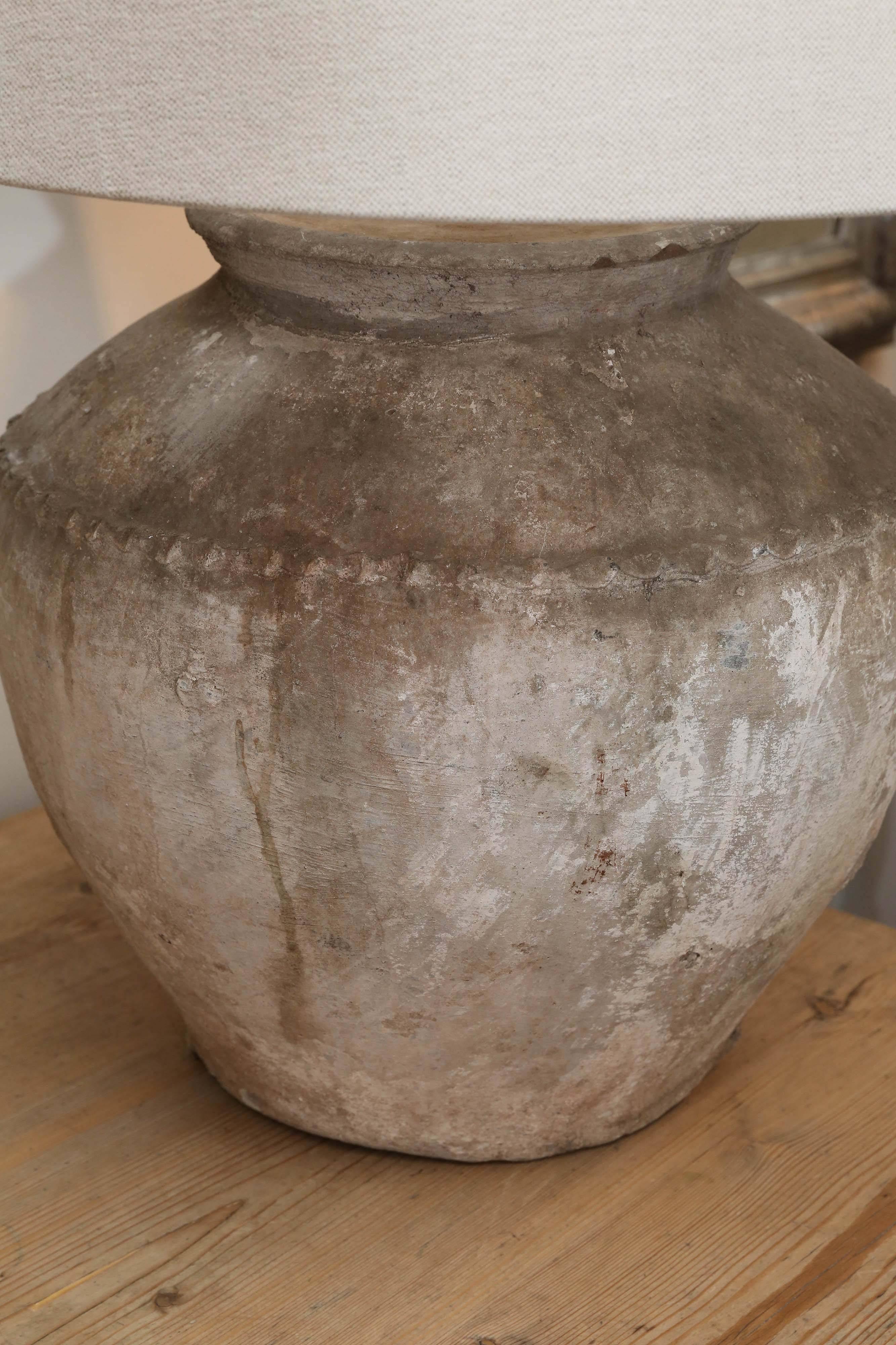 Vintage Cambodian water jar recently wired as a lamp. Handmade linen shade is included beautifully textured surface.  Vessel has a diameter of 18