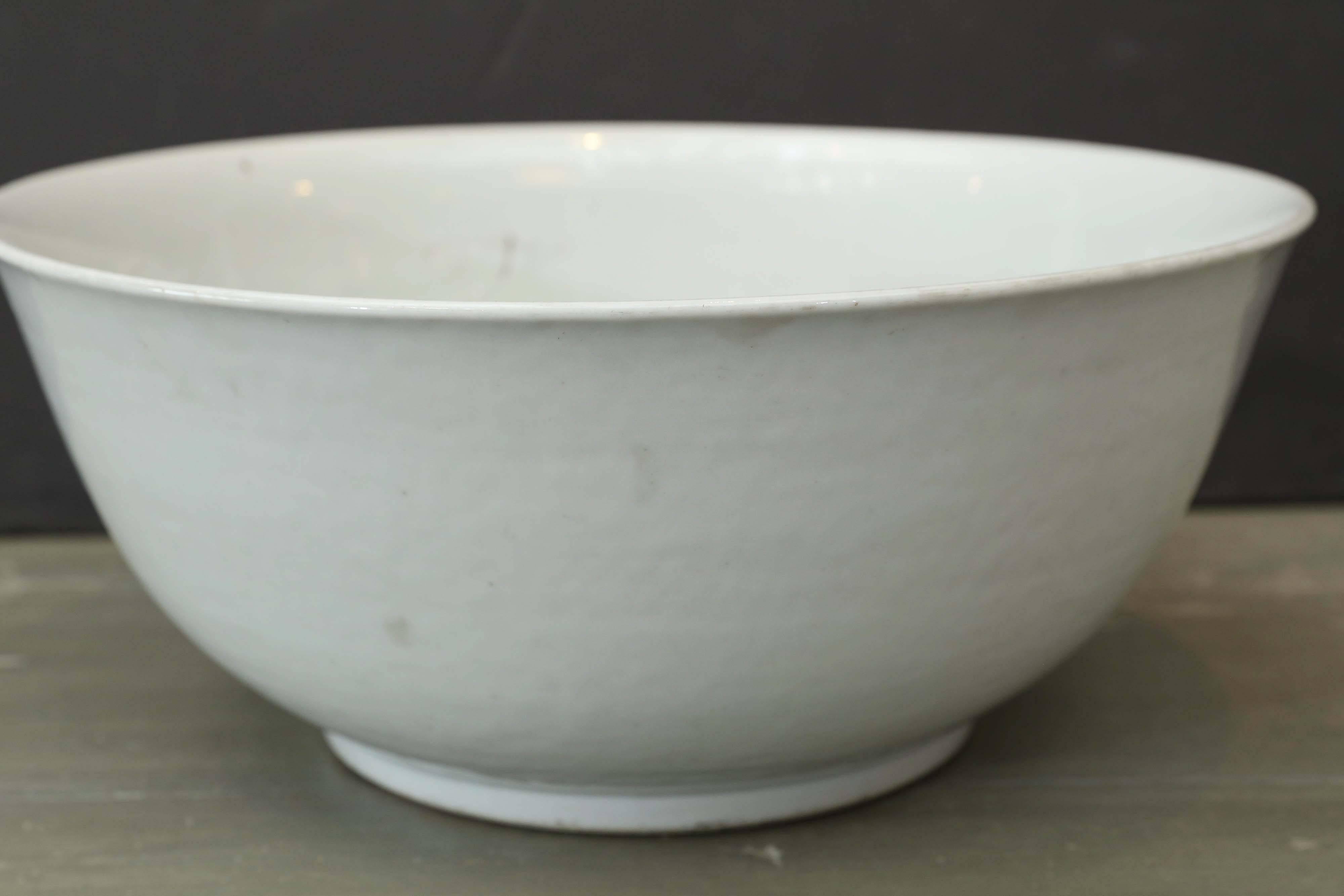 19th century white porcelain bowl from the Qing dynasty era in China. Note the irregular line to the edge of the bowl. Rust spots and firing imperfections support the age of the porcelains.