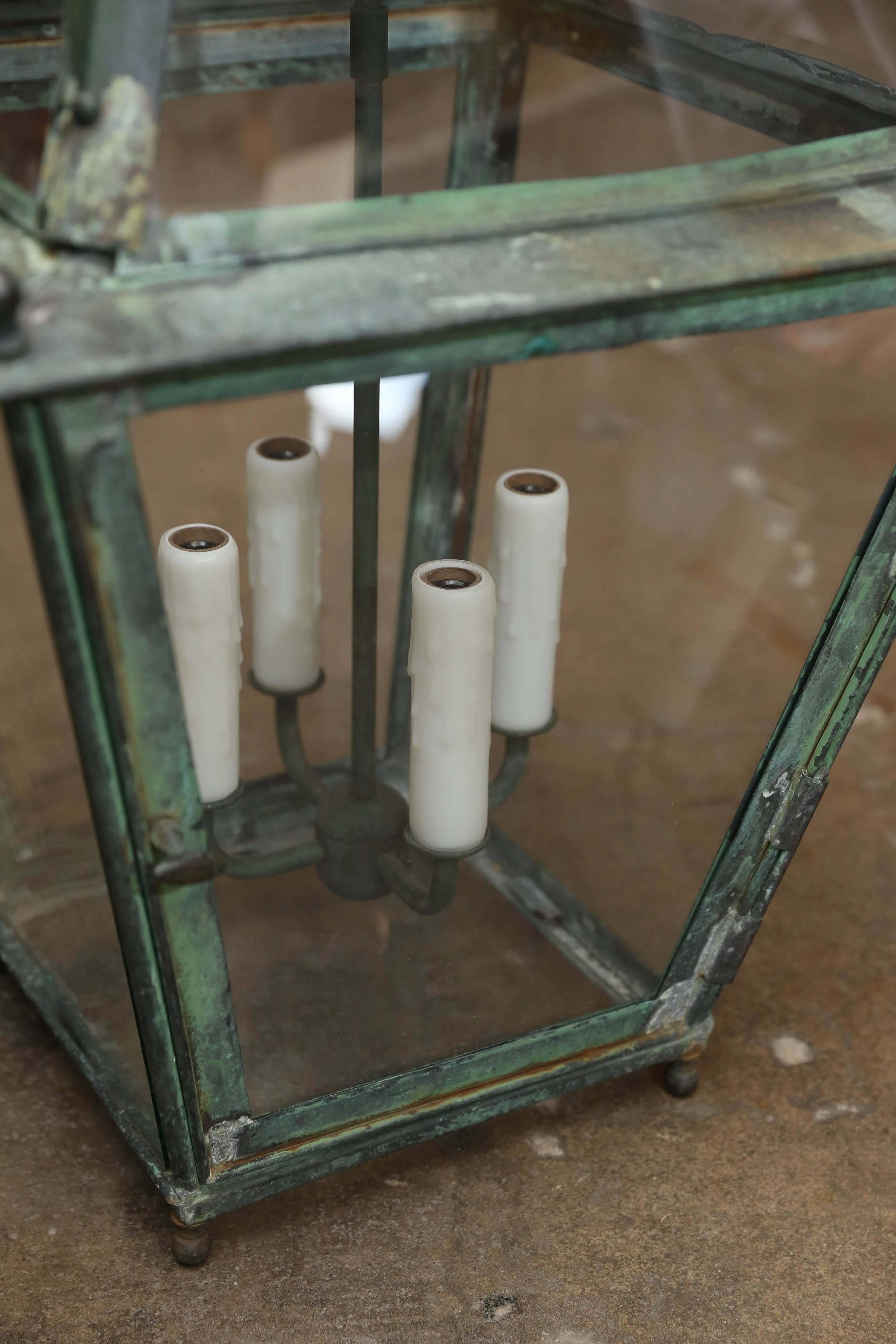 Antique 19th century, copper lantern from France that has been rewired for use in the United States. Four lights are enclosed by glass throughout with a perimeter in patinated copper. All feet and corners are detailed with a copper ball.