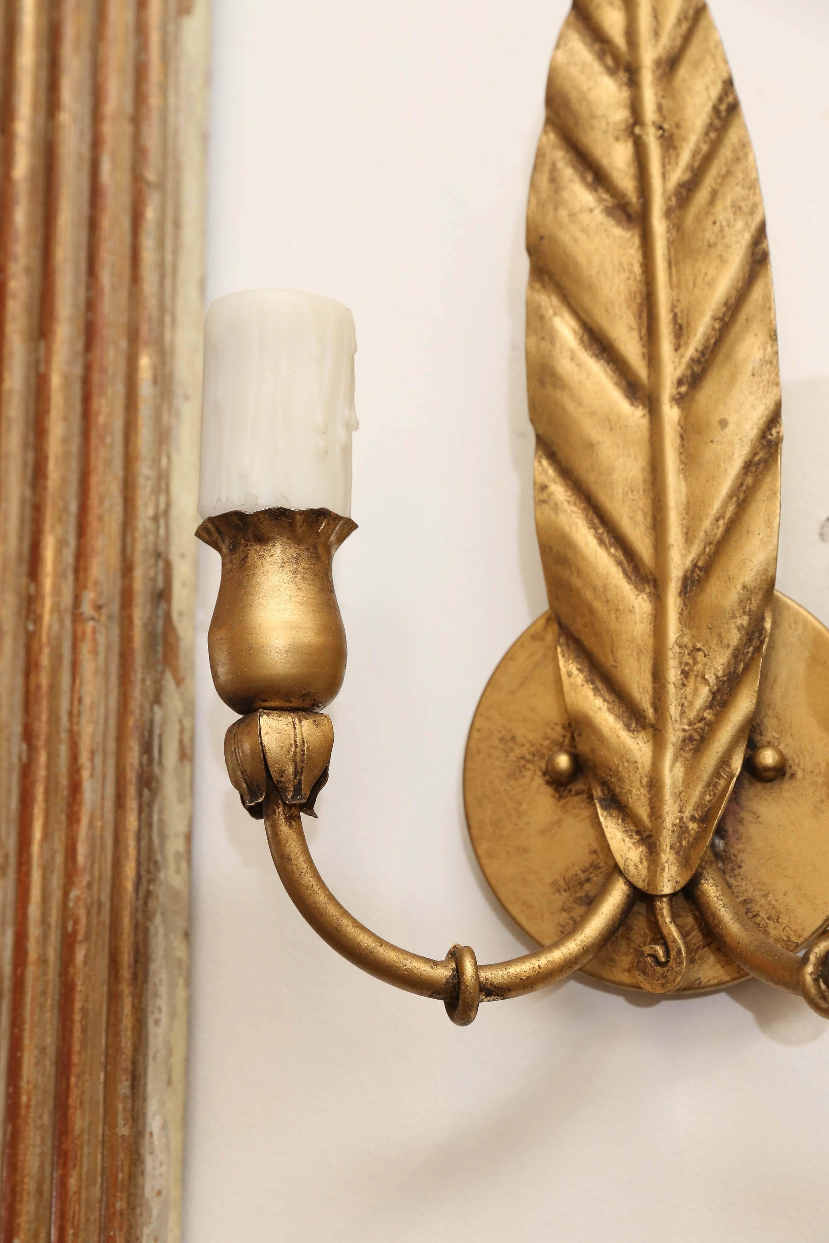 Pair of gilt metal sconces from Spain that have been recently rewired. Each one has two lights with wax sleeves.