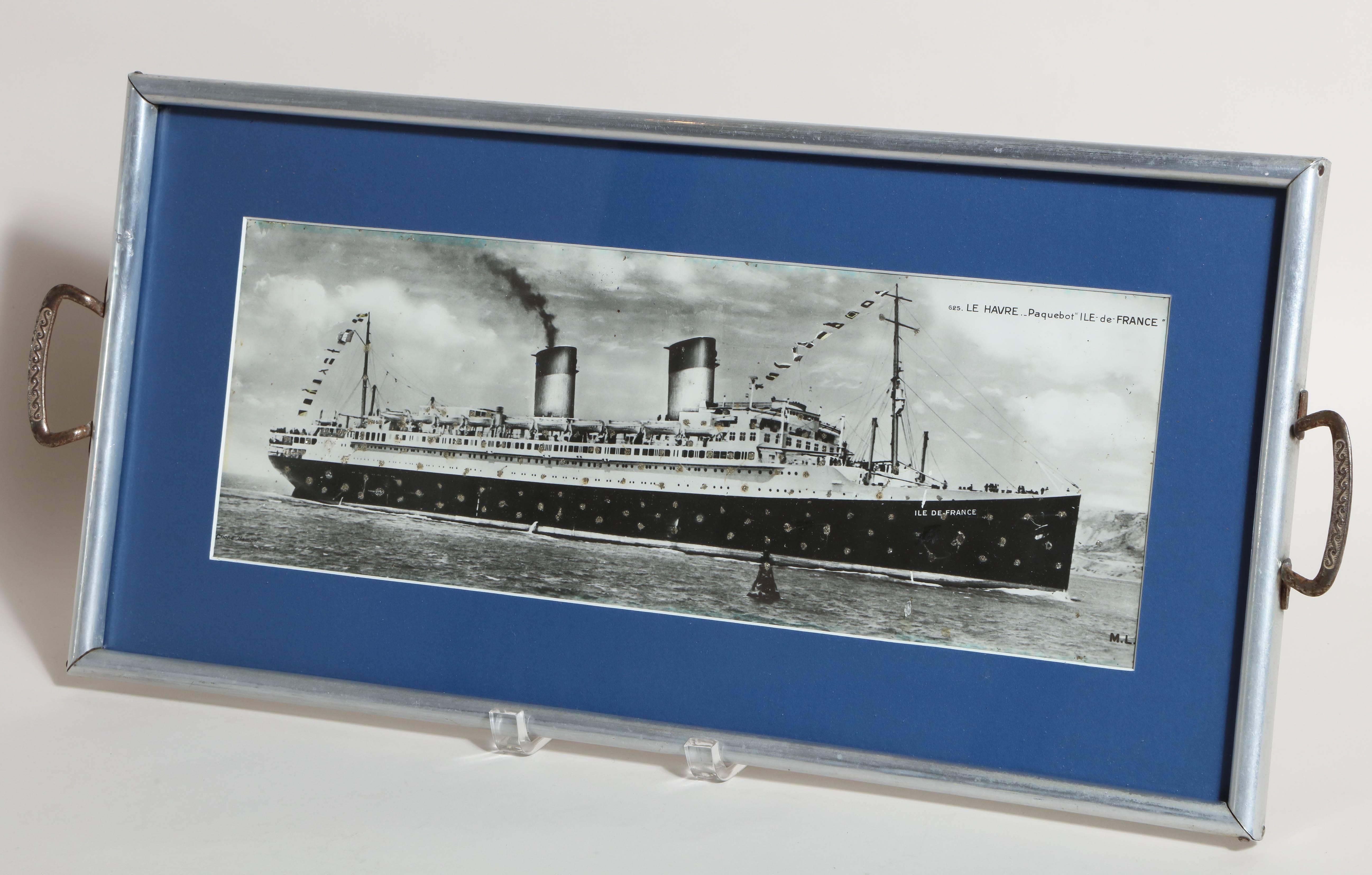 With photograph of the ship and with brass handles.
May be hung on wall or used as a tray.
 
History of the SS Ile de France:
The SS Ile de France was the first major ocean liner built after the conclusion of World War I and was the first liner